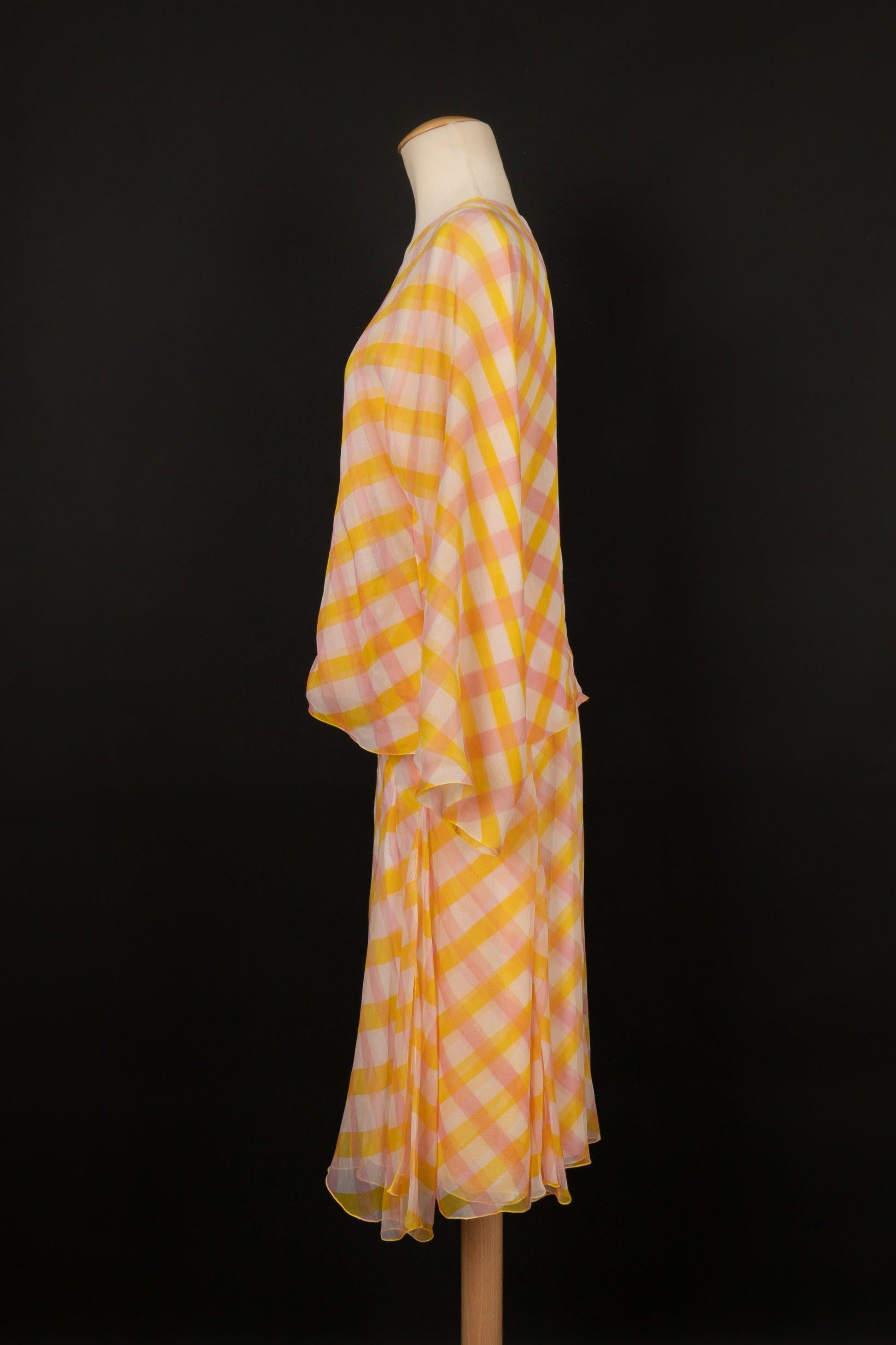 Chanel - (Made in France) Ensemble composé d'un top à nouer et d'une jupe en crêpe de mousseline de soie imprimé d'un motif à carreaux jaune, rose et blanc cassé. Taille indiquée 38FR. Croisière 1999 Collectional.

Informations complémentaires