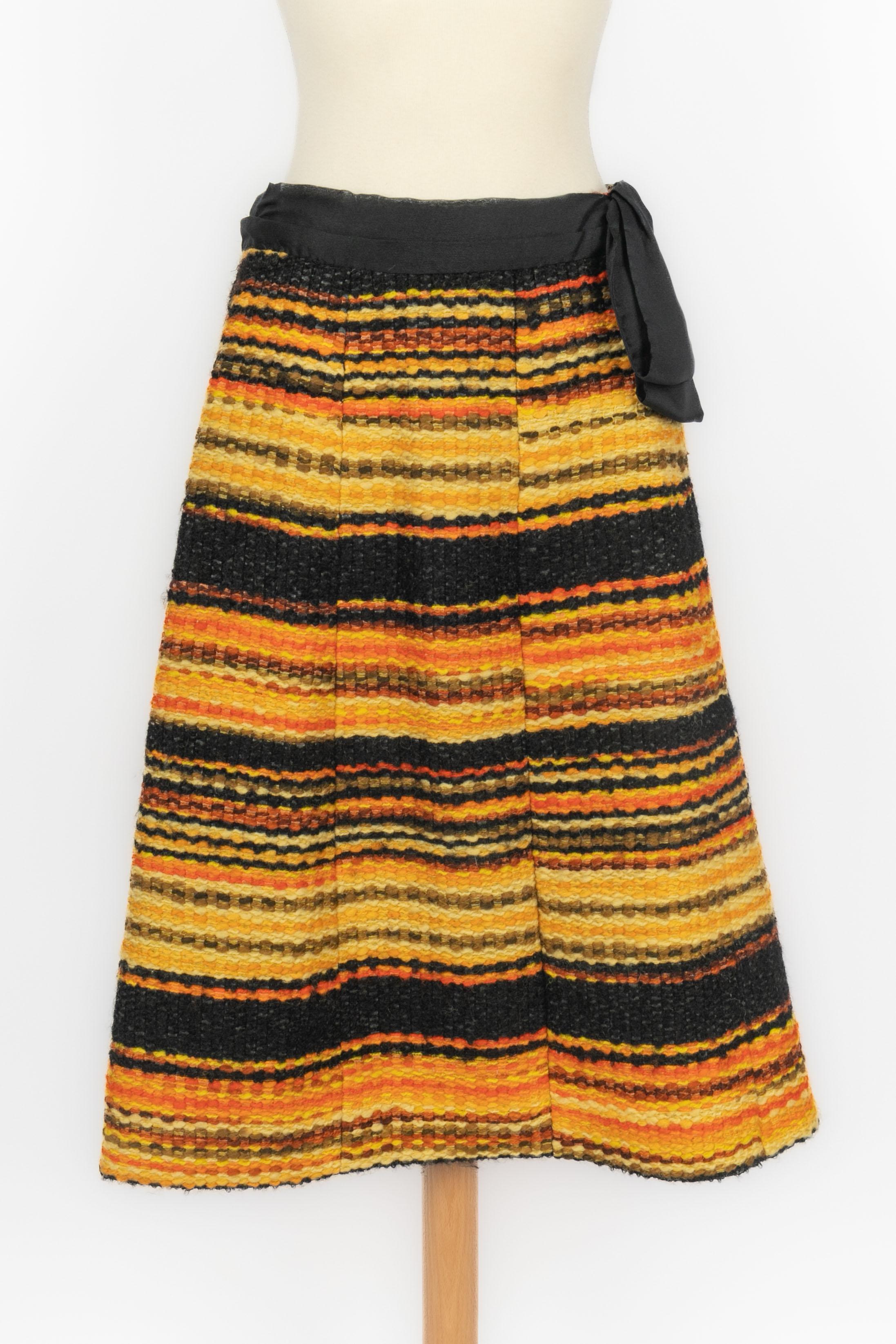 Chanel - Set in tweed nero, arancione e giallo composto da una giacca e una gonna. Non è indicata la taglia, ma si adatta a una 36FR/38FR. A  Collezione Haute Couture.

Condizioni:
Ottime condizioni

Dimensioni:
Giacca: Larghezza spalle: 36 cm -
