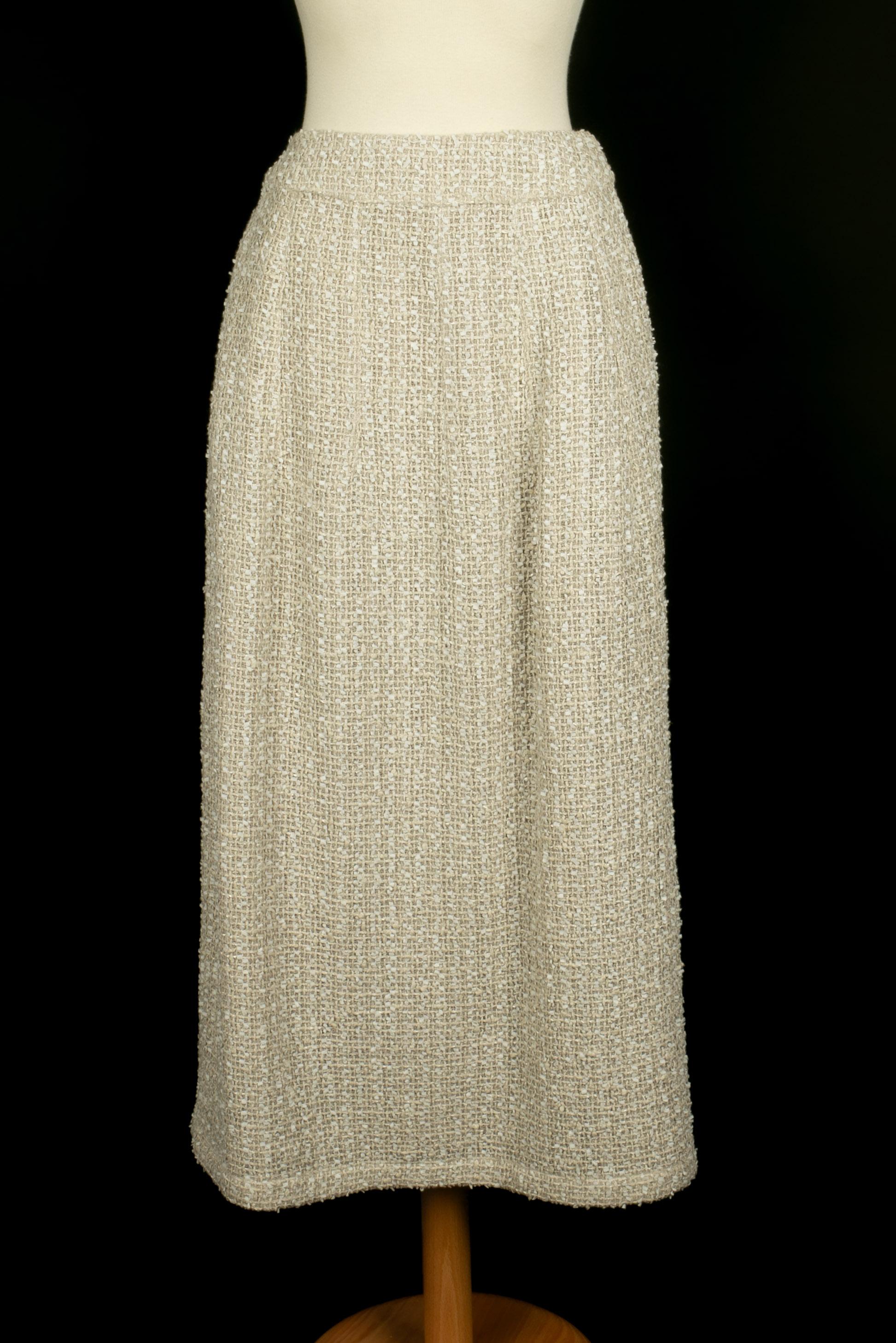 Chanel - (Made in France) Completo in tweed beige e bianco composto da una giacca e una gonna ornate da perle barocche. Taglia 36FR indicata. Collezione primavera-estate 1999 sotto la direzione artistica di Karl Lagerfeld.

Condizioni:
Ottime