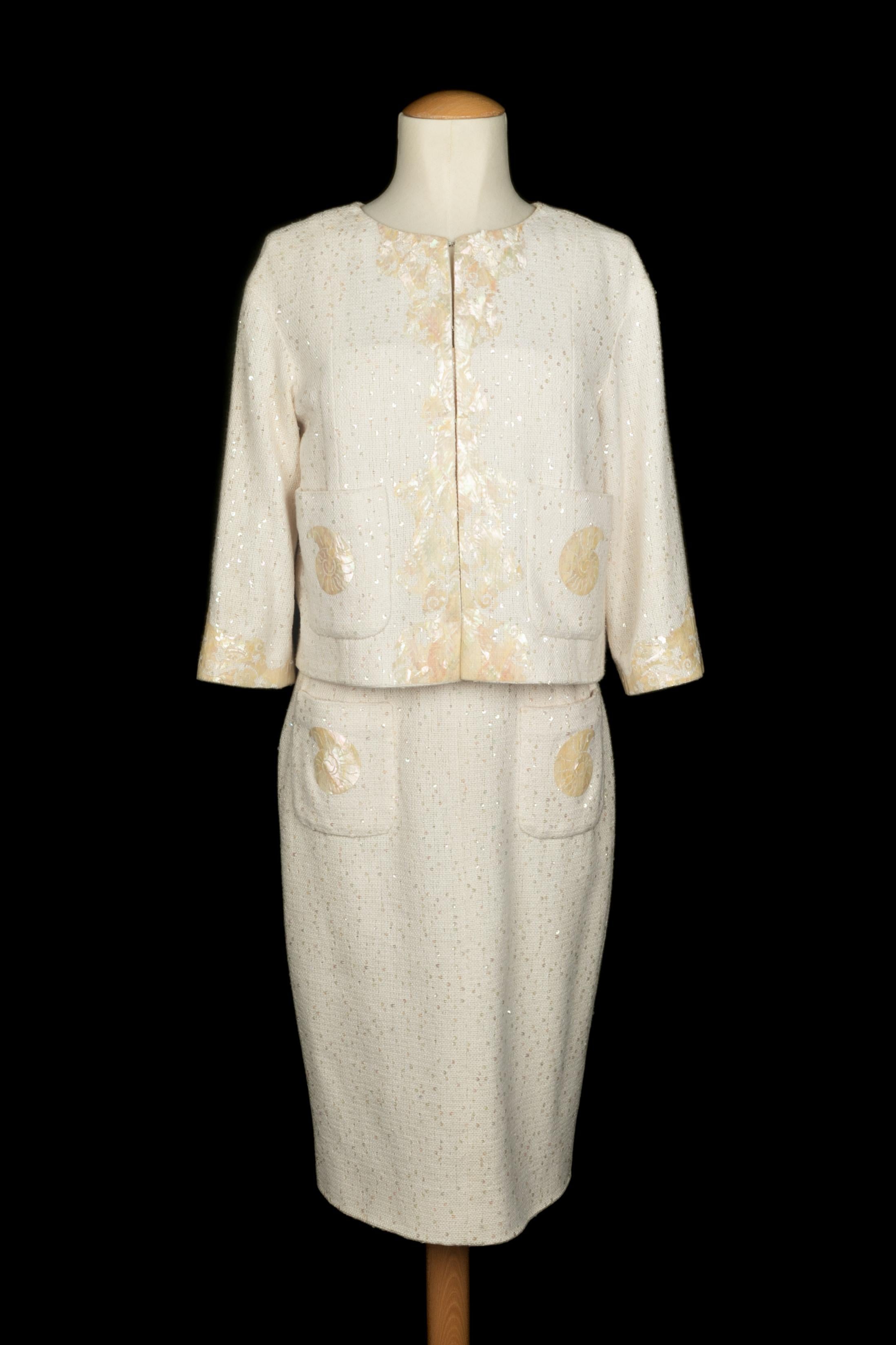 CHANEL - (Made in France) Ensemble en tweed blanc cassé composé d'une robe bustier mi-longue et d'une veste courte, à décor de coquillages. Taille 38FR indiquée. Collectional printemps-été 2012 sous la direction artistique de Karl Lagerfeld.

Condit