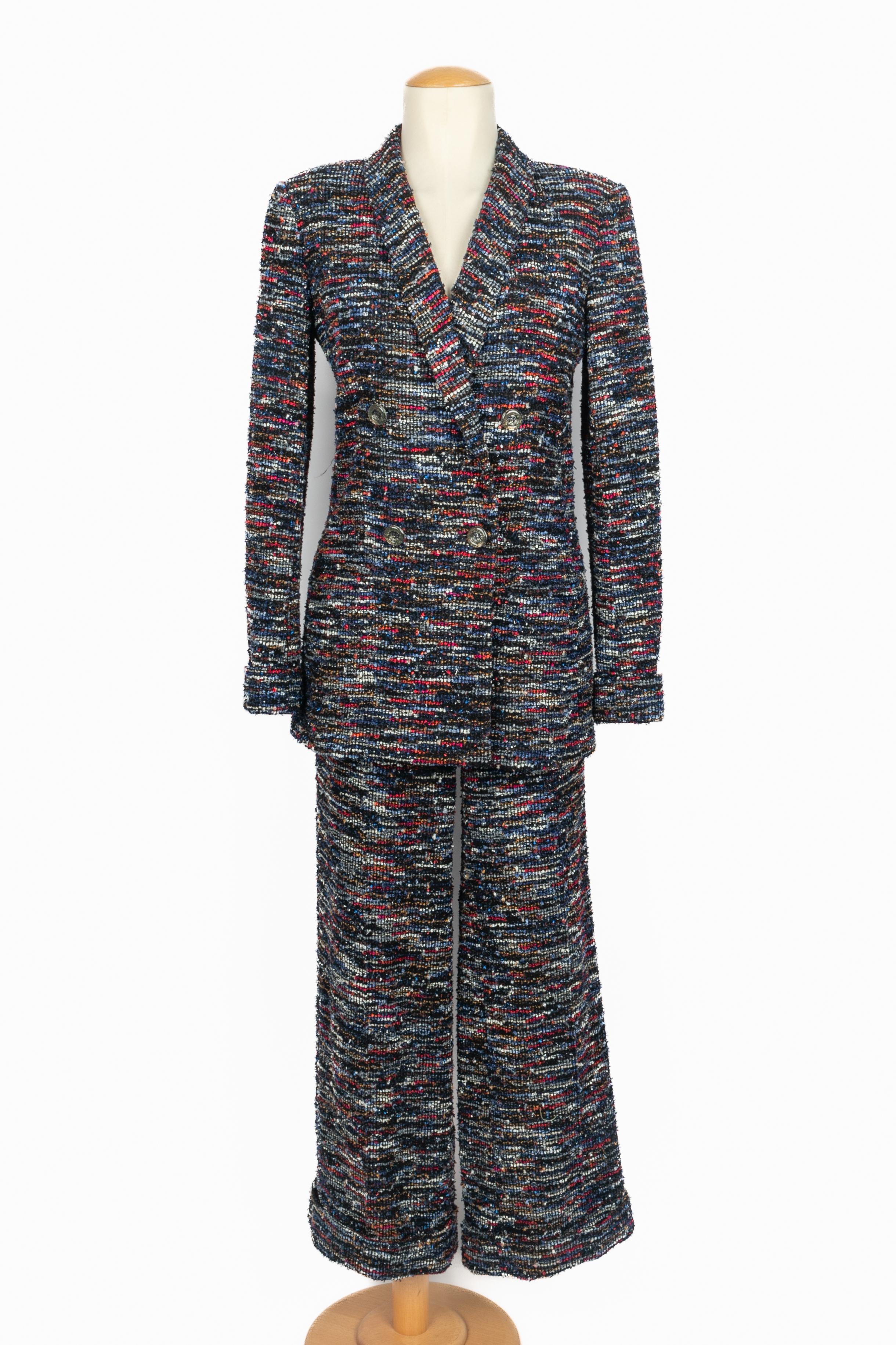 CHANEL - (Fabricado en Francia) Conjunto de tweed con lentejuelas compuesto por chaqueta y pantalón en tonos azul, rojo, negro, amarillo y blanco. Talla 38FR indicada en la chaqueta y 40FR en los pantalones. Colección Primavera-Verano 2015 bajo la