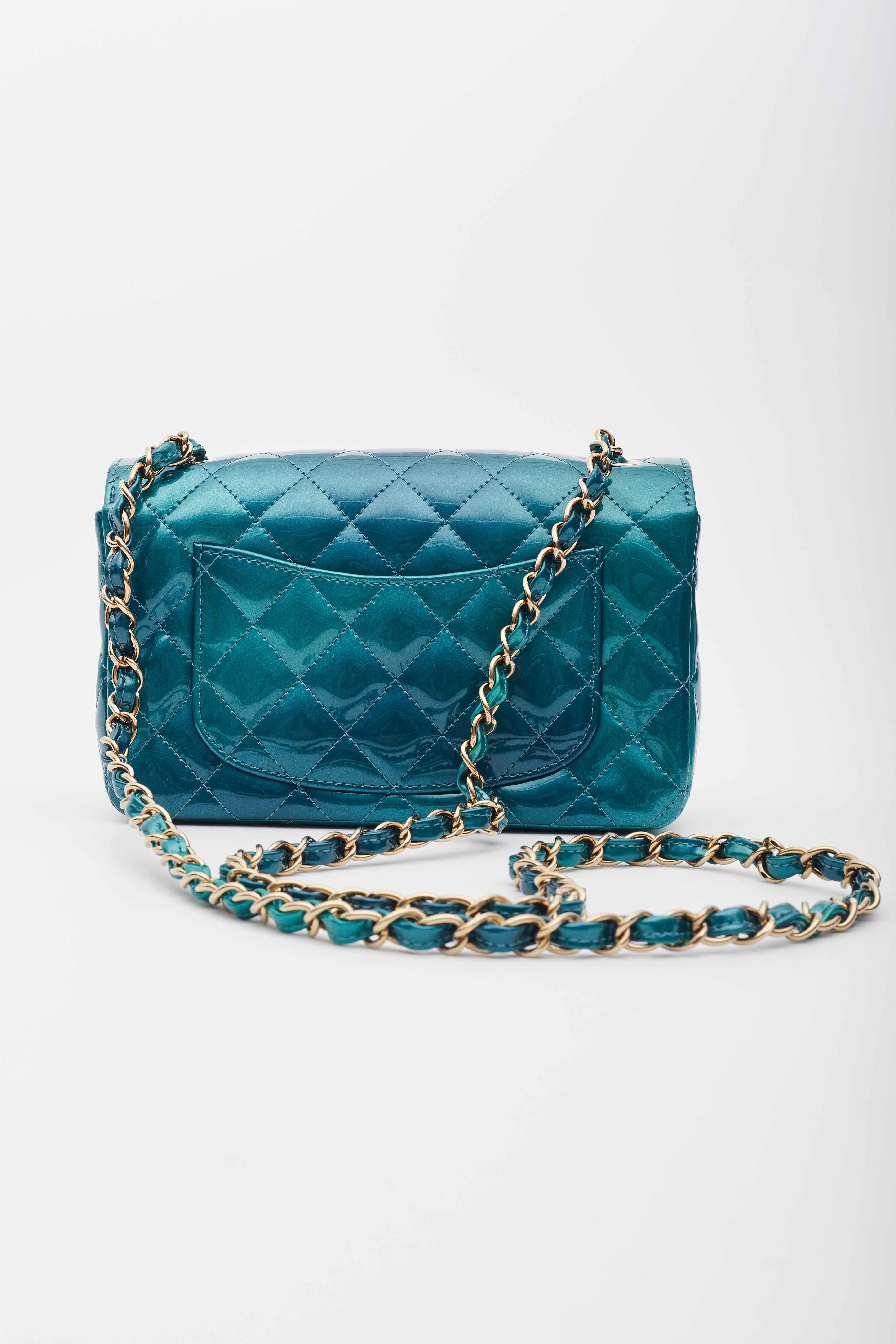 This bag is made out of luxurious diamond quilted iridescent patent leather in gradient blue to green. The bag features a crossbody leather threaded gold chain link shoulder strap, a frontal flap, and a gold Chanel CC turn lock. This opens to a blue