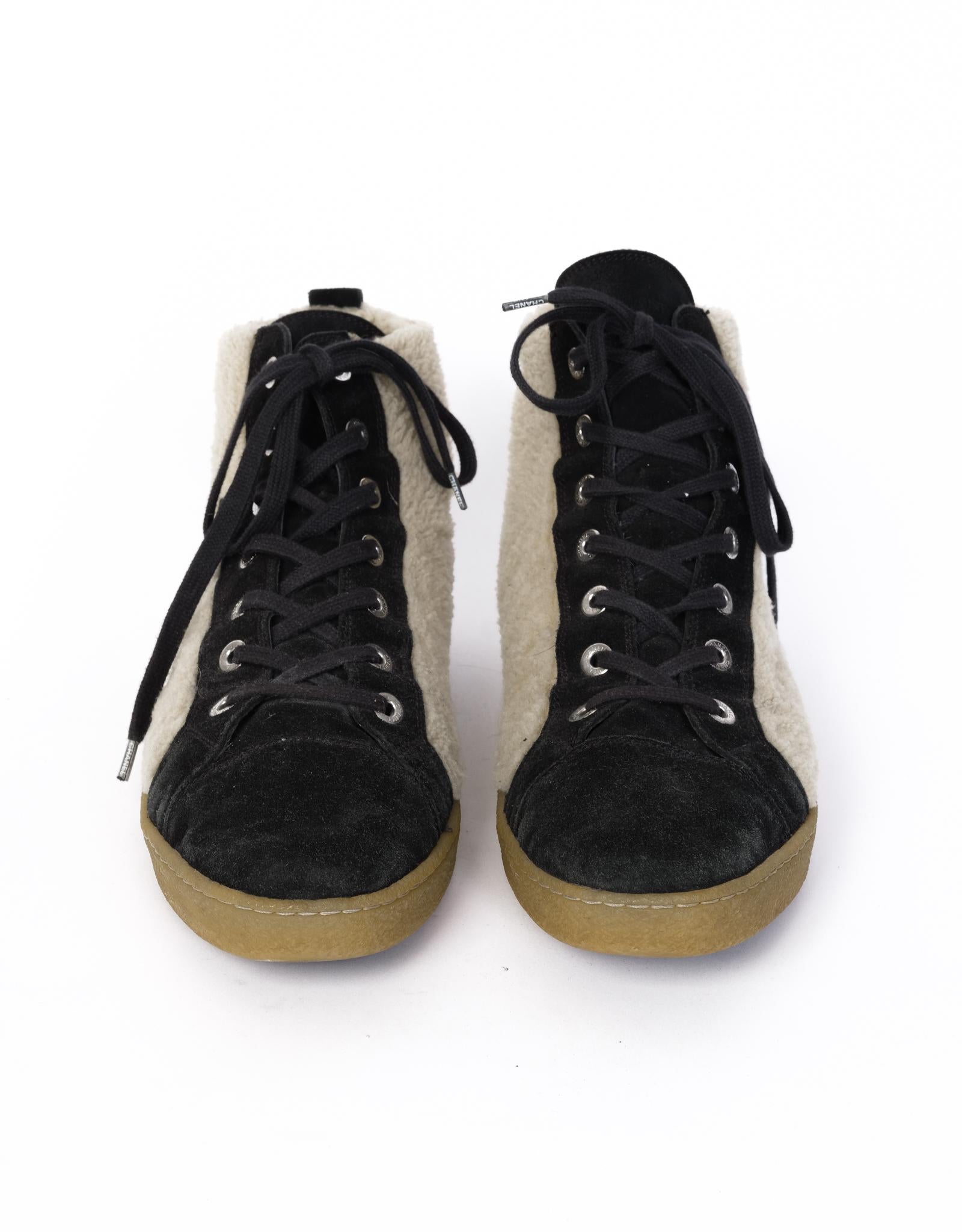 Black and tan suede and shearling Chanel round-toe high-top sneakers with interlocking CC accents at sides, rubber soles and lace-up closures at uppers. 

COLOR/Material: Black suede/ Cream Shearling
SIZE: 44 EU / 11 US MENS
PLATFORM HEIGHT: .75”