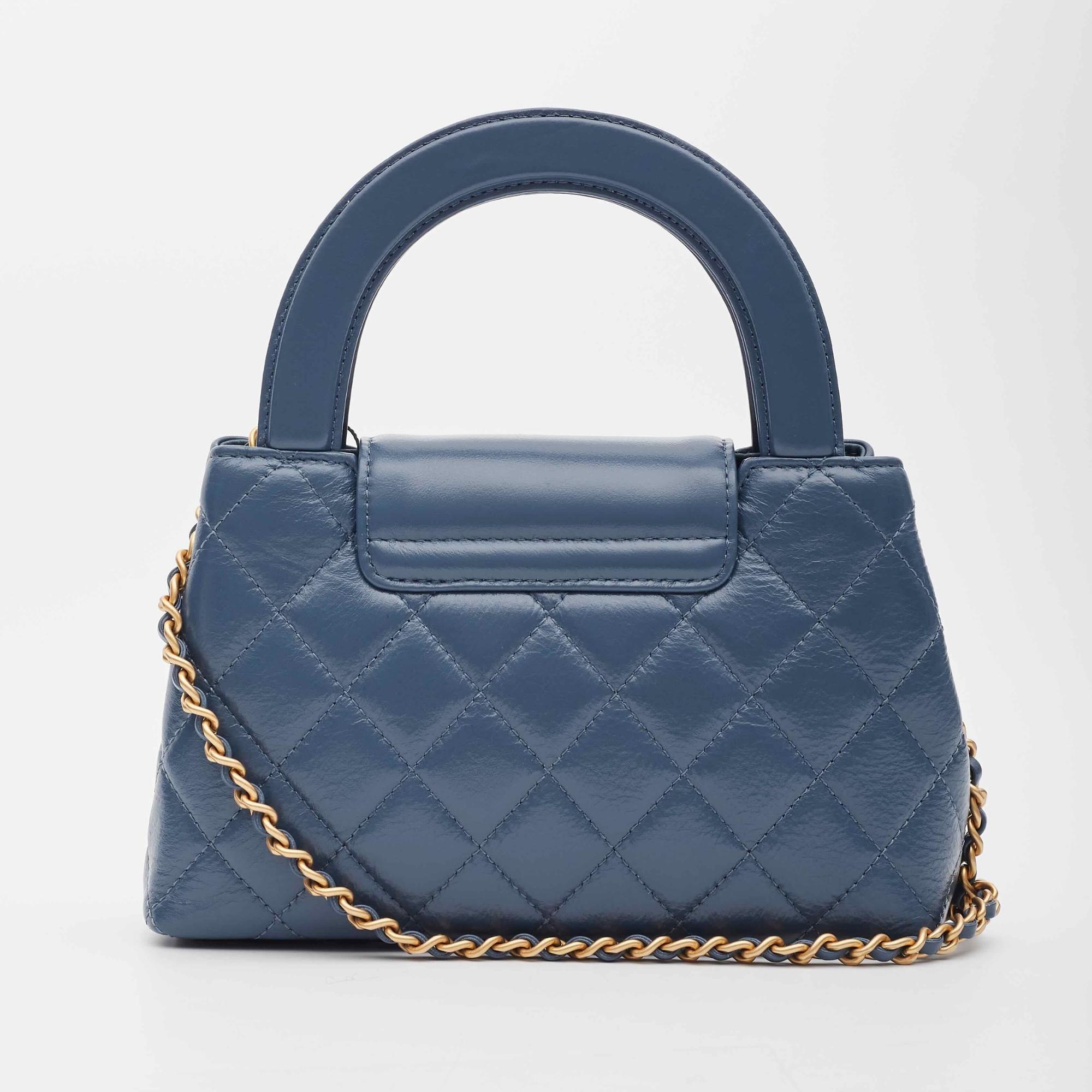 Chanel Top Handle Bag. From the Fall/Winter 2023 Collection by Virginie Viard. This mini bag is a twist on an archival Chanel bag, featuring a long crossbody chain strap. This dual top handle bag is quilted in shiny aged calfskin leather in blue,