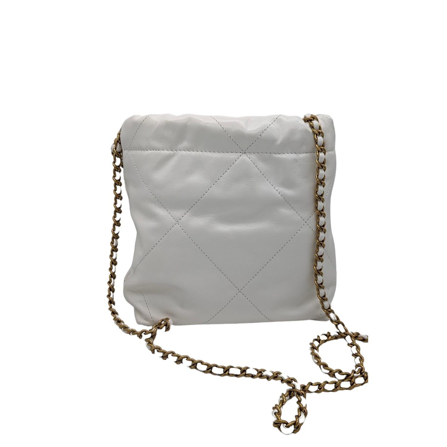 This chic bag is crafted with smooth calfskin diamond-stitched leather in white. The bag features a leather threaded aged gold chain link shoulder strap joined to a thin rolled leather strap, a leather threaded chain link handle, an aged gold