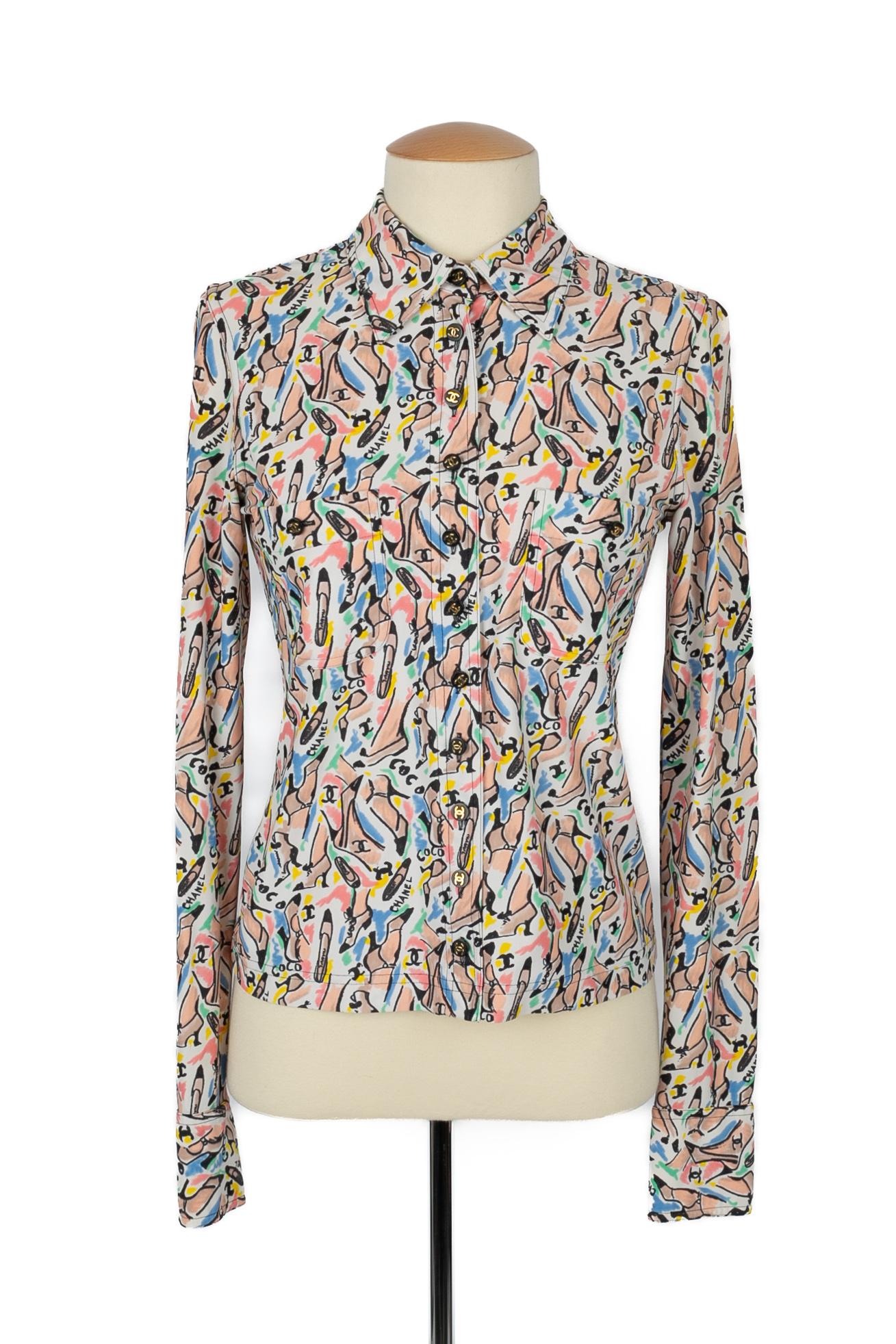 CHANEL - (Fabriqué en France) Chemise à motif multicolore. Aucune taille n'est indiquée, il convient à un 38FR/40FR. Collectional printemps-été 1995 sous la direction artistique de Karl Lagerfeld.

Condit :
Très bon état.

Dimensions :
Largeur des