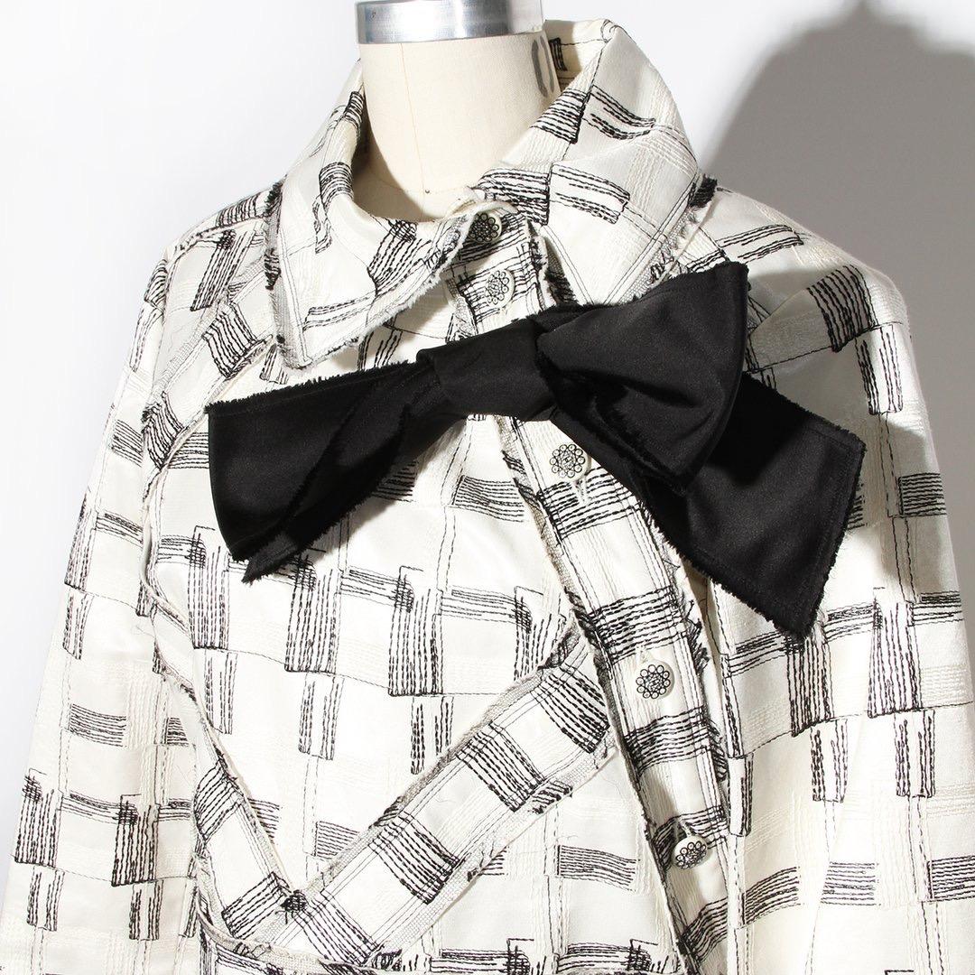 Vintage Chanel by Karl Lagerfeld Shirtdress 
Spring / Summer 2009 Ready-to-Wear Collection 
Look 13 
Made in France 
Ivory 
Black and white geometric stitch detailing 
Asymmetrical button closure up left side of dress
Oversize black bow on left side