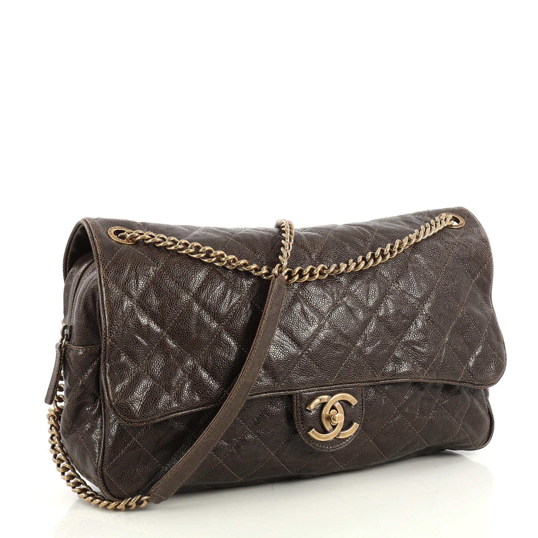 This Chanel Shiva Flap Bag Quilted Caviar Maxi, crafted from brown quilted caviar leather, features chain link strap and brass-tone hardware. Its CC turn-lock closure opens to a red fabric interior with zip pocket. Hologram sticker reads: 16602837.