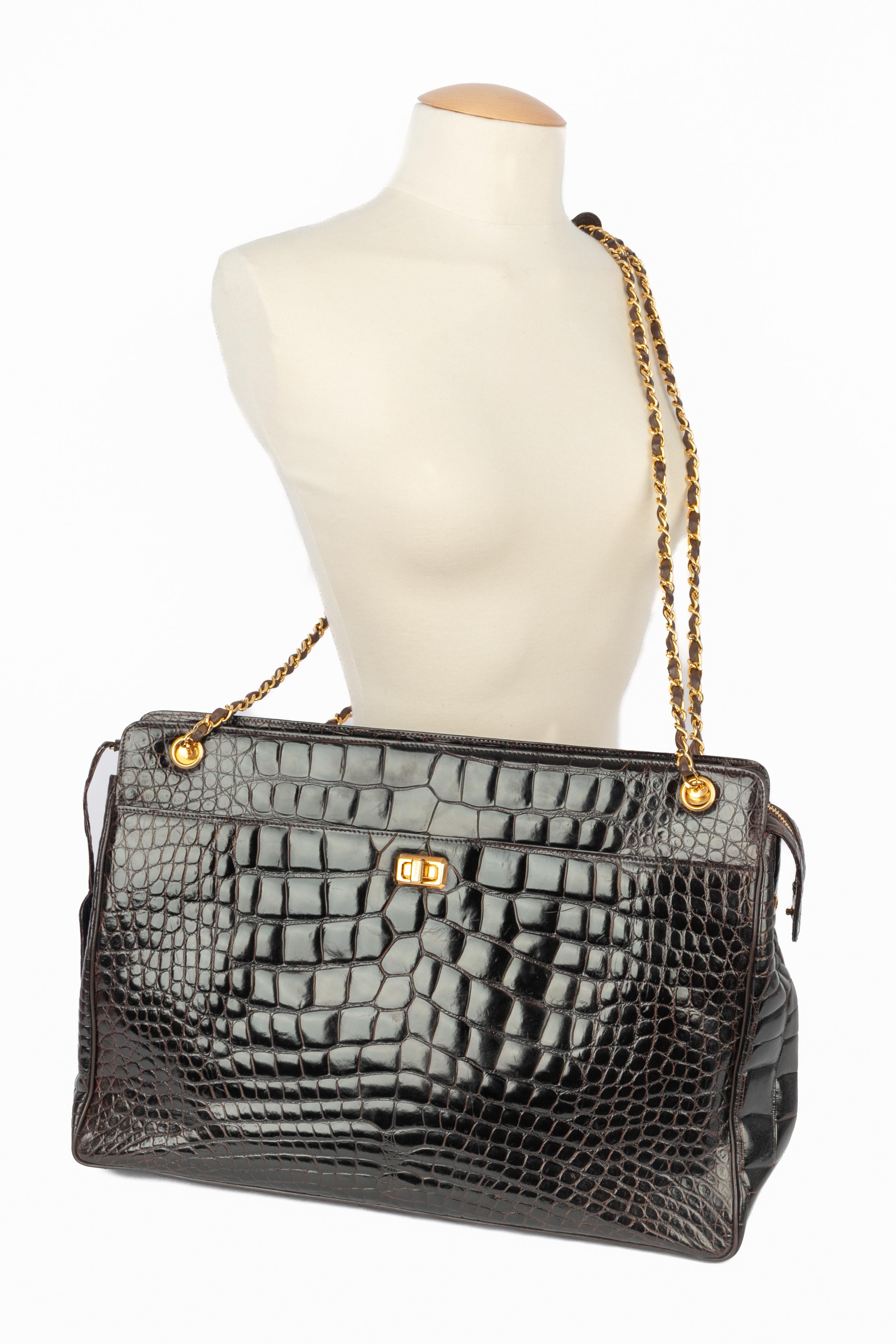 CHANEL - (Made in France) Chocolate-color crocodile bag. Lamb leather inside, golden metal chain handle interlaced with leather. Piece with a serial number. To be mentioned, a leather enveloppe is missing inside. A 2000-2002 Collection under the