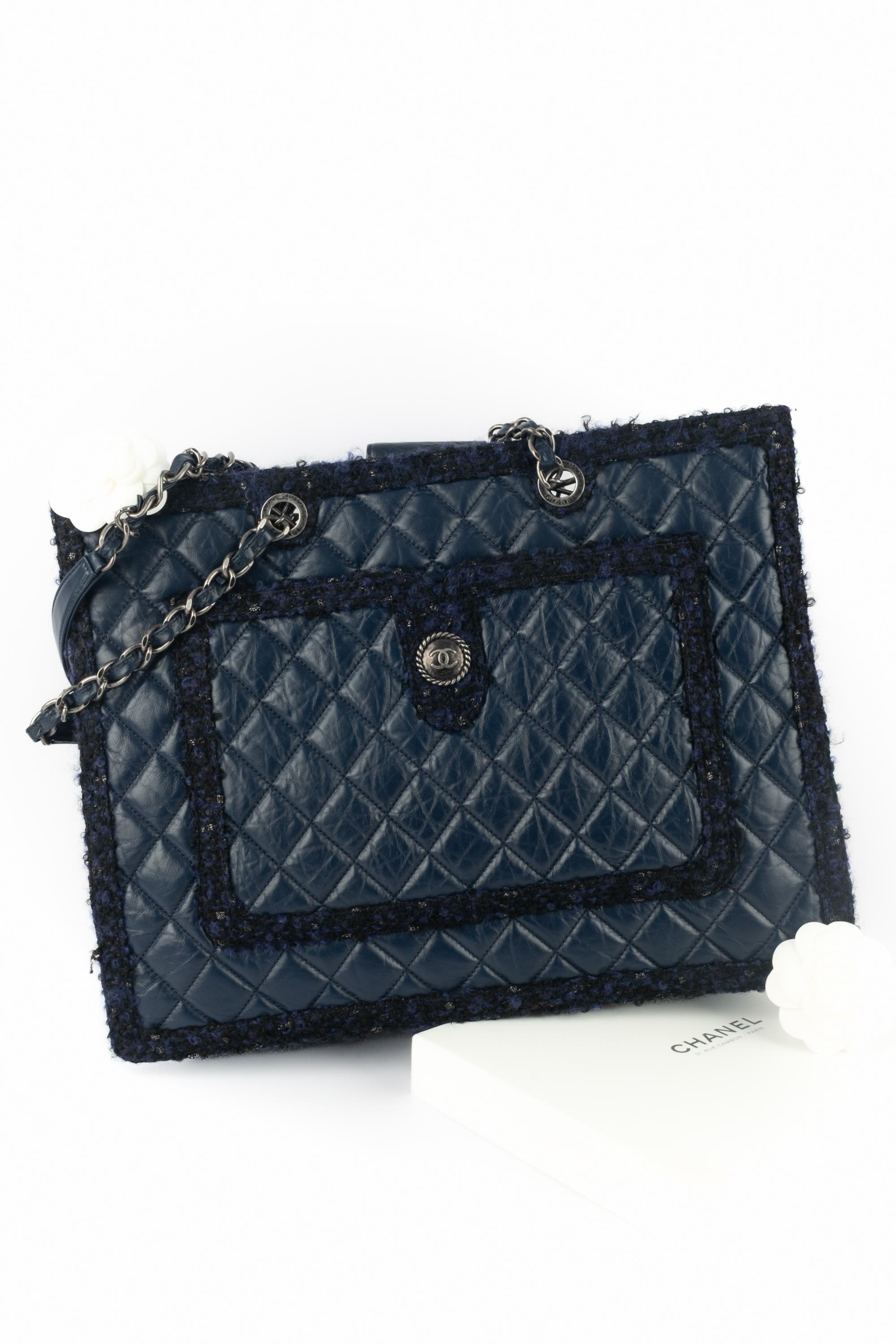 CHANEL - (Made in Italy) Navy-blue quilted calfskin shopping bag trimmed with same-color tweed. Double interlaced chain handle, shoulder tabs, outside pockets. Piece with a Hologramme. A 2014 Collection under the artistic direction of Karl