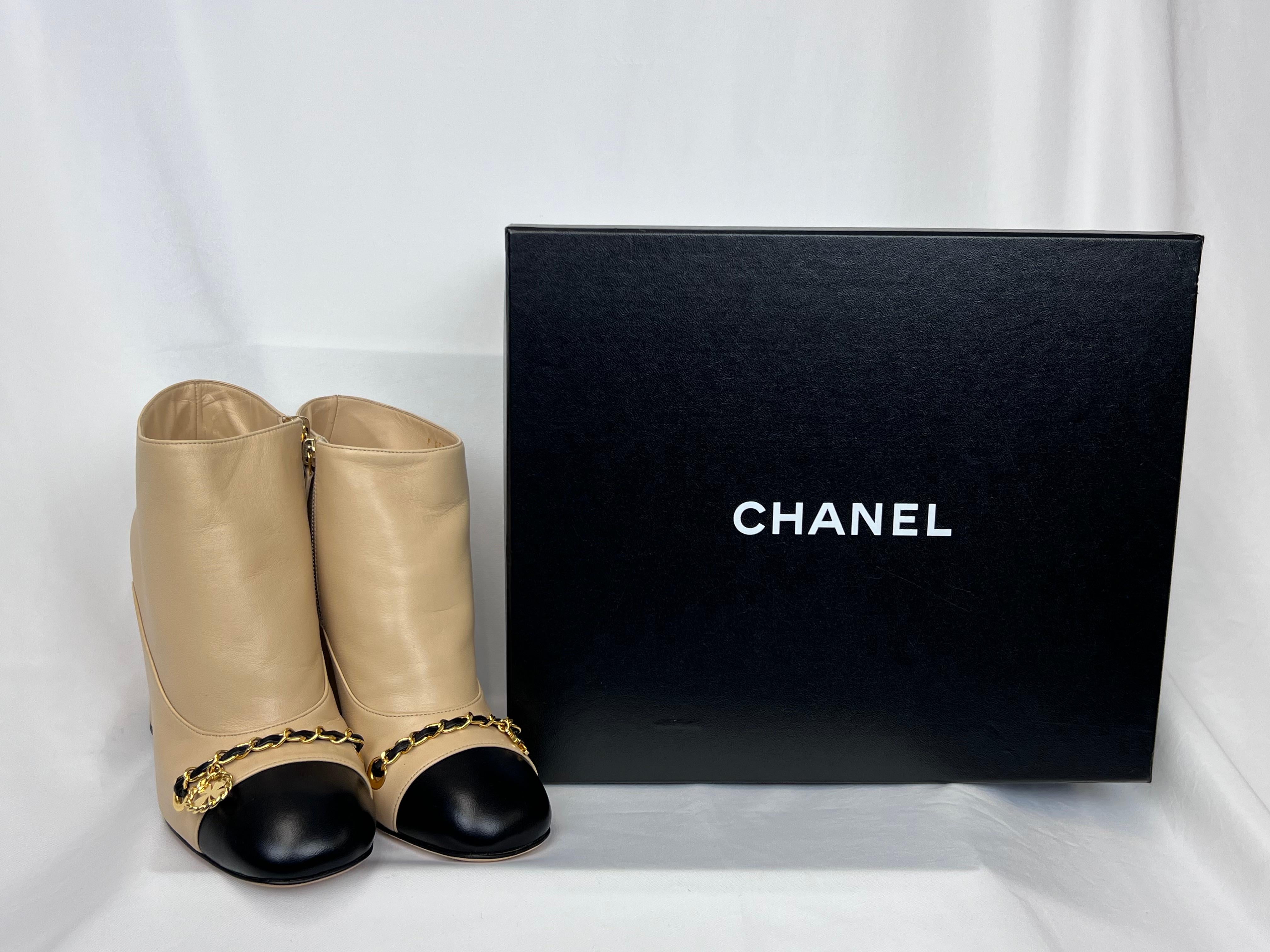 Chanel Short Beige/Black Lambskin Boots. Gold Chain and Charm (CC and Clover). 

Size: 36.5

Condition: Excellent, never worn

Includes Chanel Box and Dust Bag