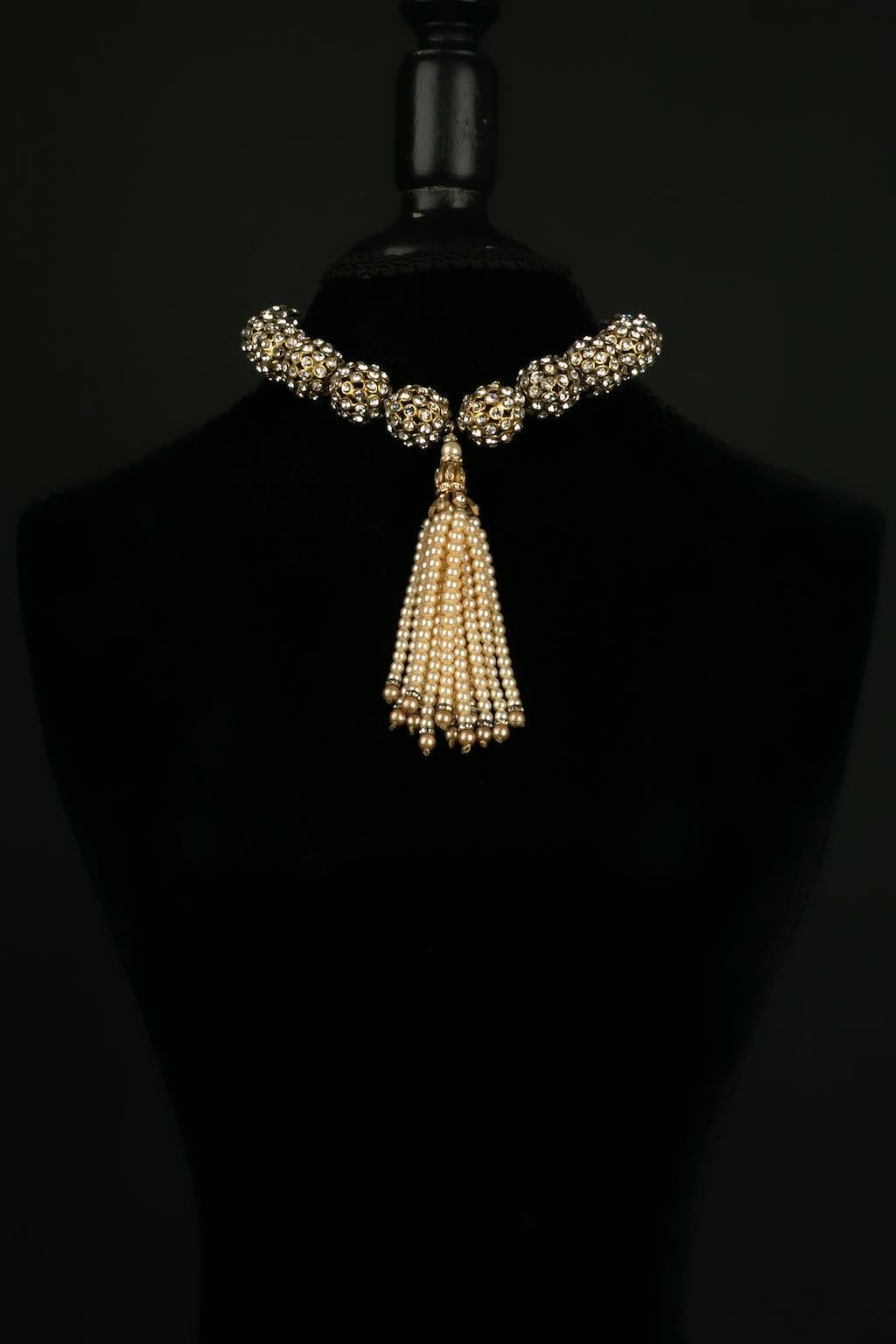 Chanel -(Made in France) Collier court composé de perles en métal doré pavées de strass, retenant un pompon de perles nacrées. Modèle rare de la collection 1983.

Informations complémentaires : 
Dimensions : Longueur : 43 cm - Largeur : 13 cm