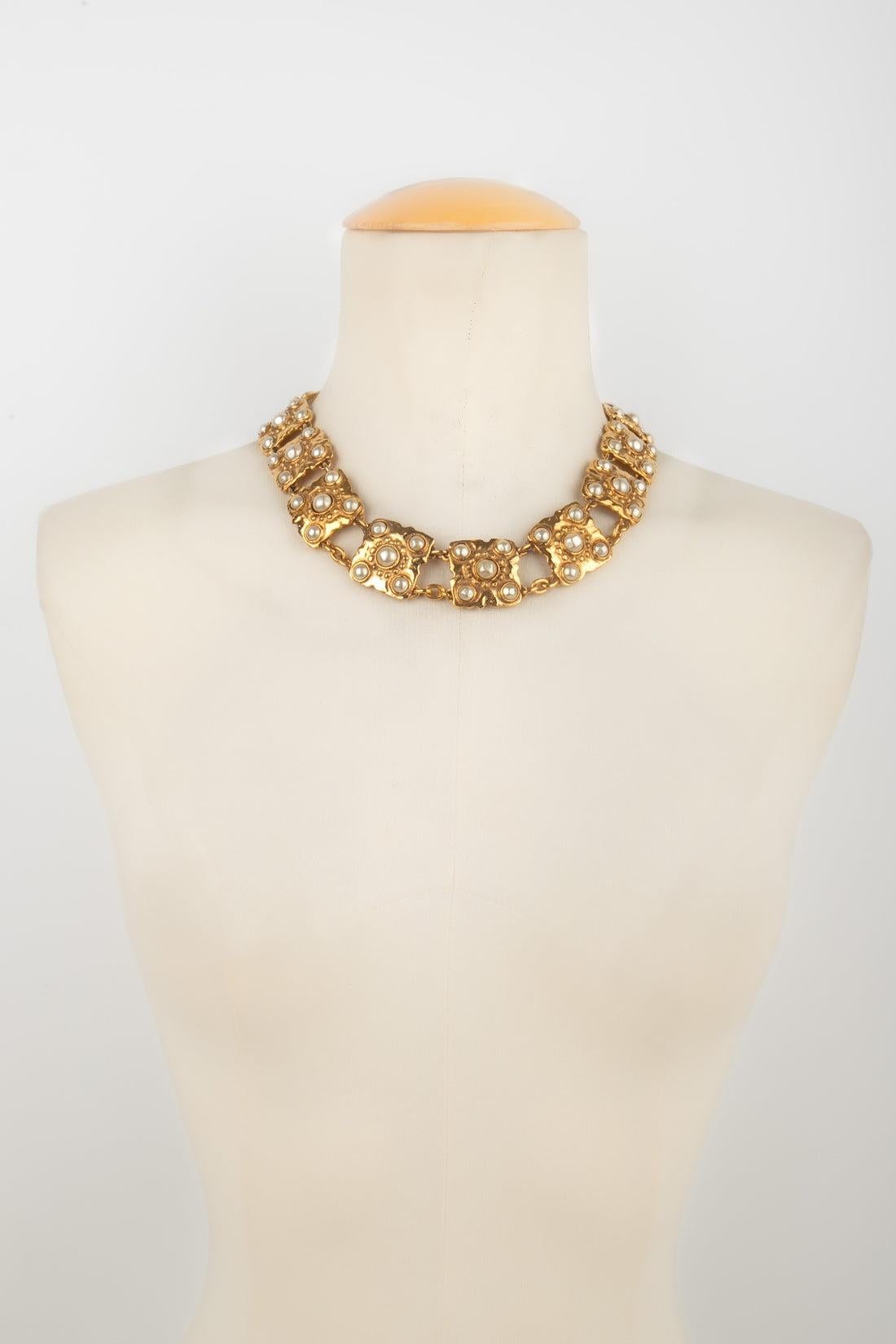 Chanel - (Made in France) Articulated golden metal short necklace ornamented with pearly cabochons. Jewelry from the middle of the 1980s.  - Gravé du S de solde.

Additional information:
Condition: Very good condition
Dimensions: Length: from 39 cm