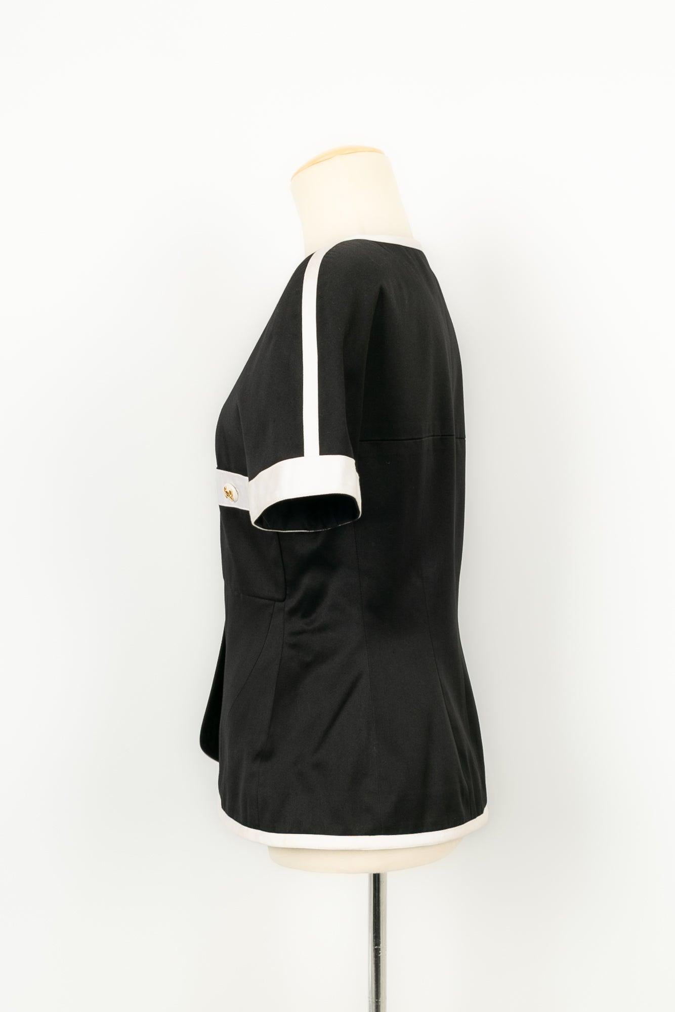 Chanel - Short-sleeved jacket in black satin edged with white satin. No size indicated, it fits a 40FR/42FR.

Additional information:
Condition: Very good condition
Dimensions: Shoulder width: 40 cm - Chest: 43 cm - Waist: 41 cm - Sleeve length: 22