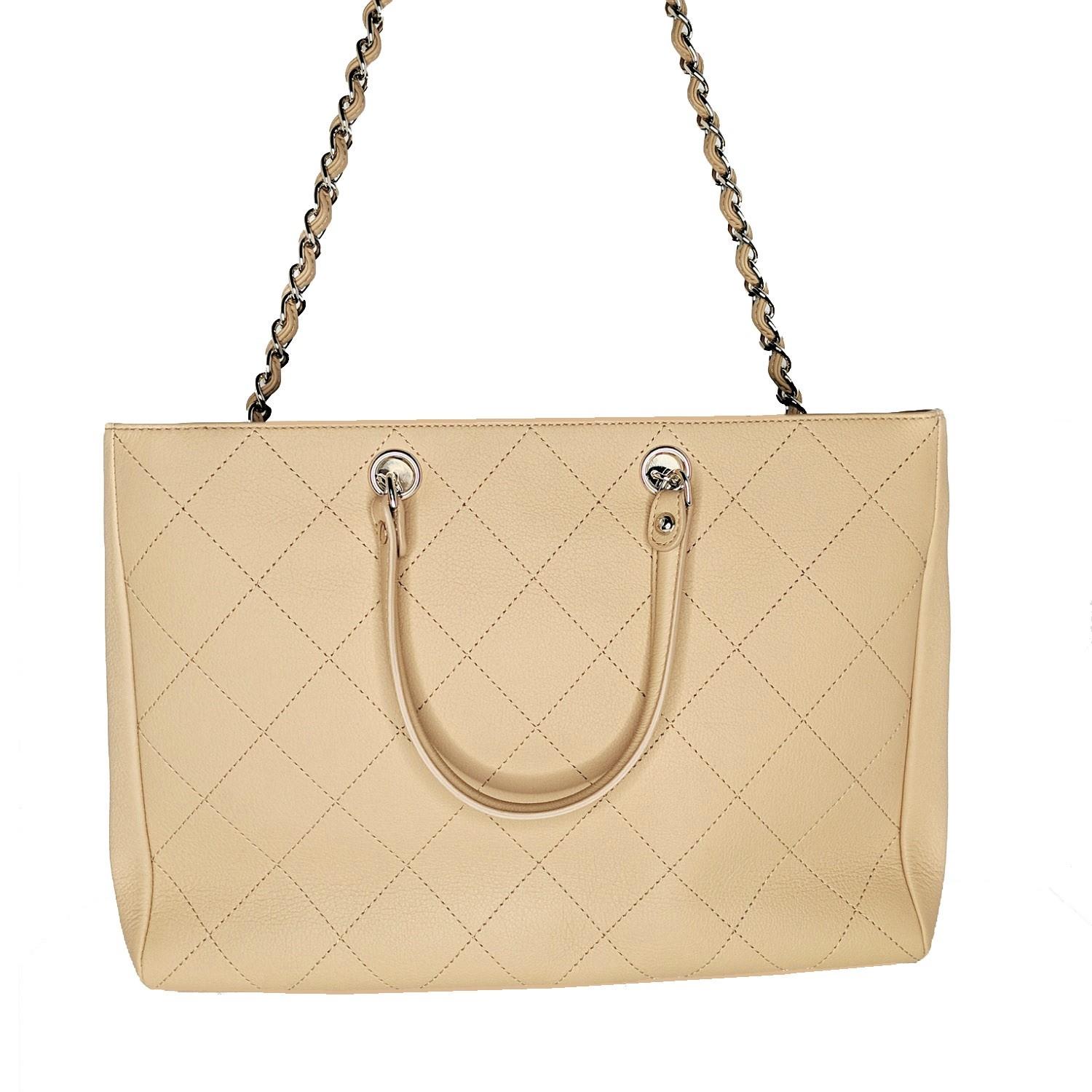 From the Spring 2019 Collection. Light beige bullskin Chanel Medium Tote with gold-tone hardware, dual rolled top handles, single chain-link and leather woven shoulder strap, logo adornment at front face, protective feet at base, tonal grosgrain