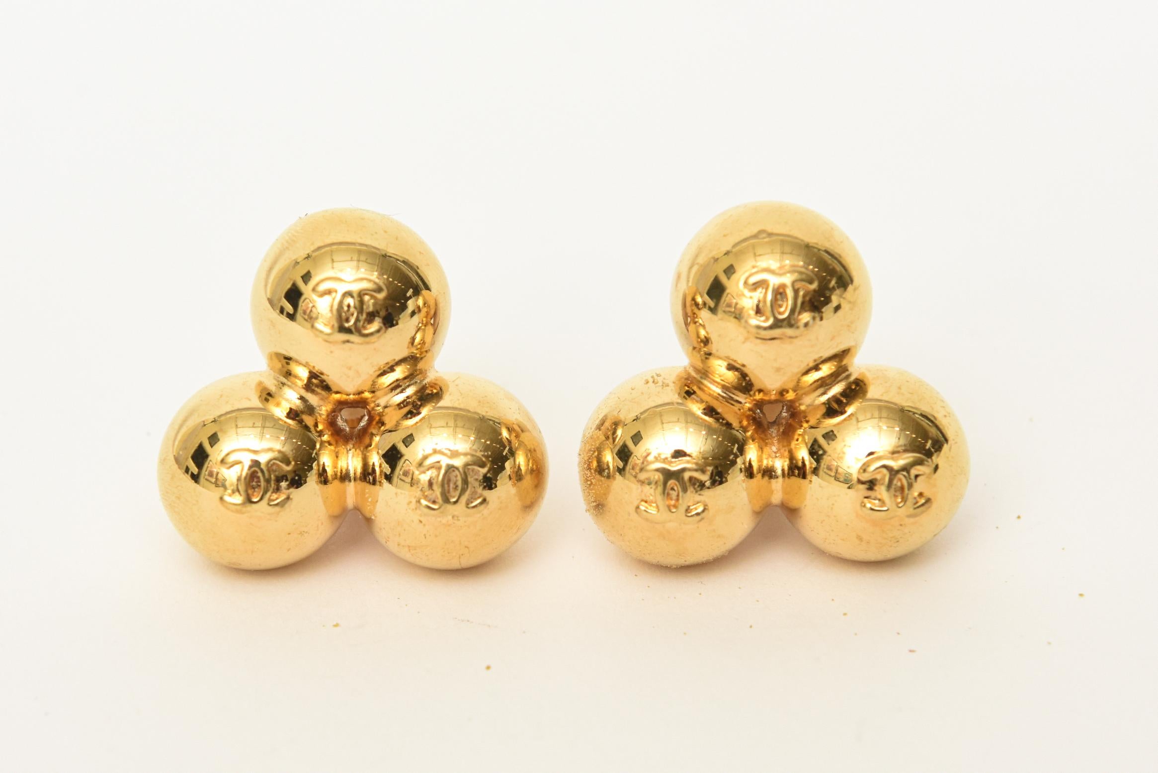 These ultra fabulous, unusual and sculptural signed period vintage Chanel gold plated 3 cluster ball or sphere clip on earrings are so chic. They are geometric and have the signature interlocking CC's on each ball. From the 90's. They are signed