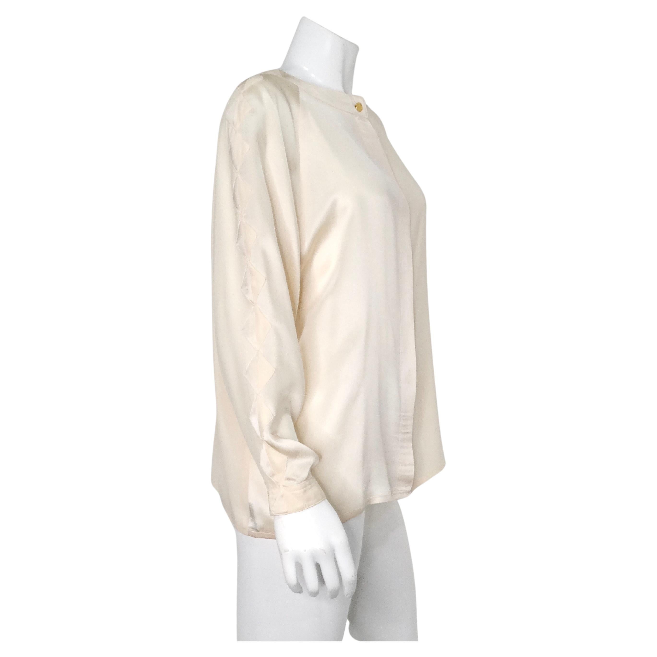 Cette blouse boutonnée en soie rose bébé de Chanel, datant des années 1980, est un exemple d'élégance intemporelle et de savoir-faire sophistiqué. Confectionnée en soie luxueuse dans une délicate teinte rose layette, cette blouse présente des