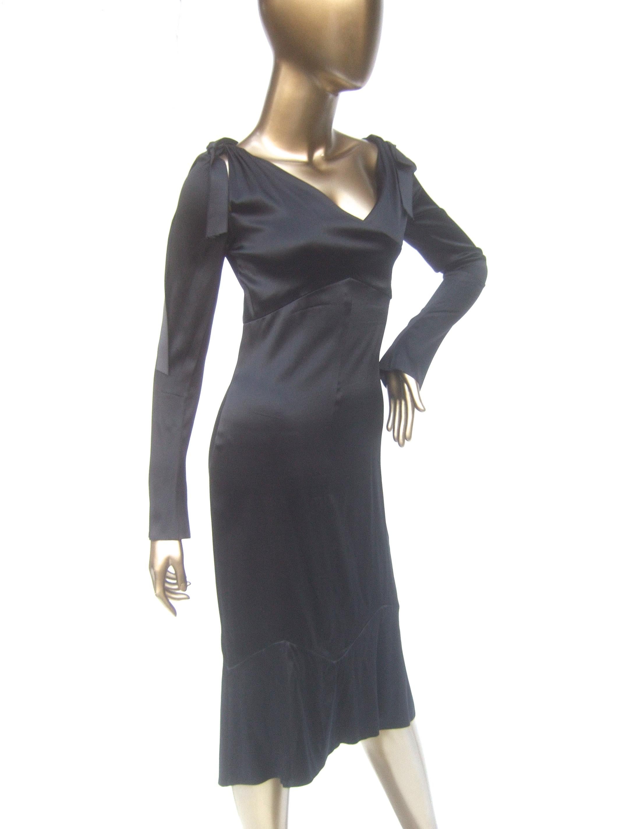 Chanel Silk charmeuse ribbon trim cocktail dress c 1990s Size 34 
The elegant Chanel black silk evening dress is designed 
with slit detail on both shoulders accented with black ribbons

The lower hemline area is designed with a subtle geometric