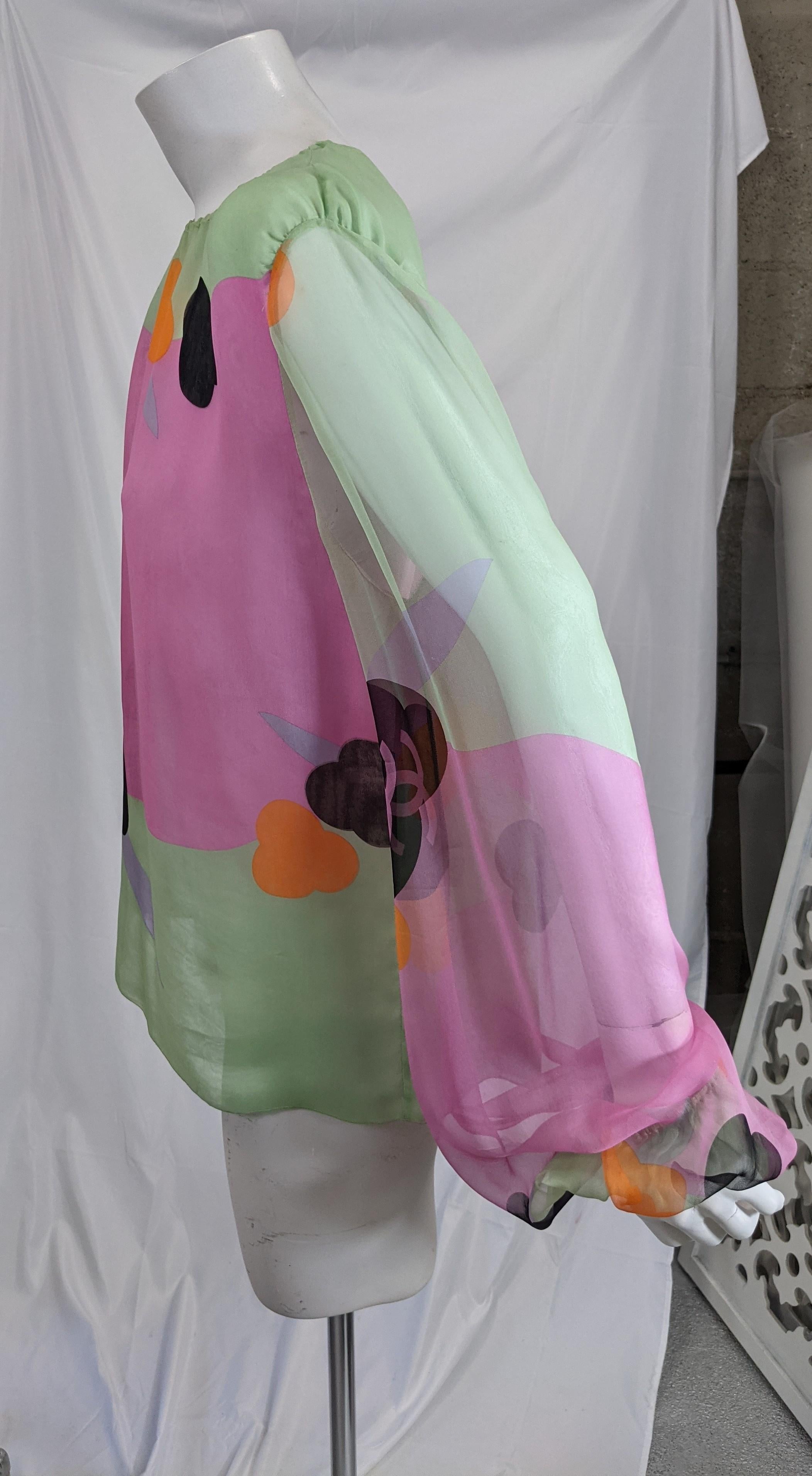 Fun Chanel Silk Chiffon Logo Blouse with large dramatic full cut bishop sleeves from the 1990's by Karl Lagerfeld for Chanel. Abstract floral silk chiffon print is sheer but entire bodice is in doubled chiffon for more coverage but is not opaque.
