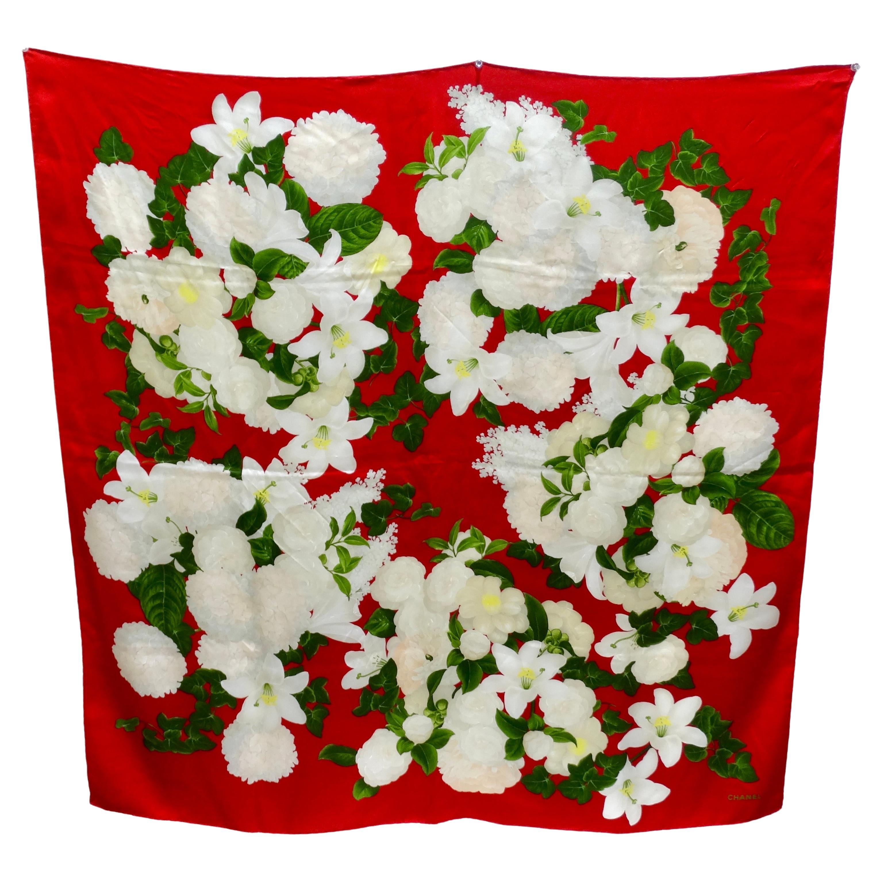 This silk Chanel scarf gives you a beautifully soft silk paired with a print of lillies and hydrangeas. The print keeps it elegant by only using white flowers but keeps it fresh and modern with a highly contrasting red. It features a small 