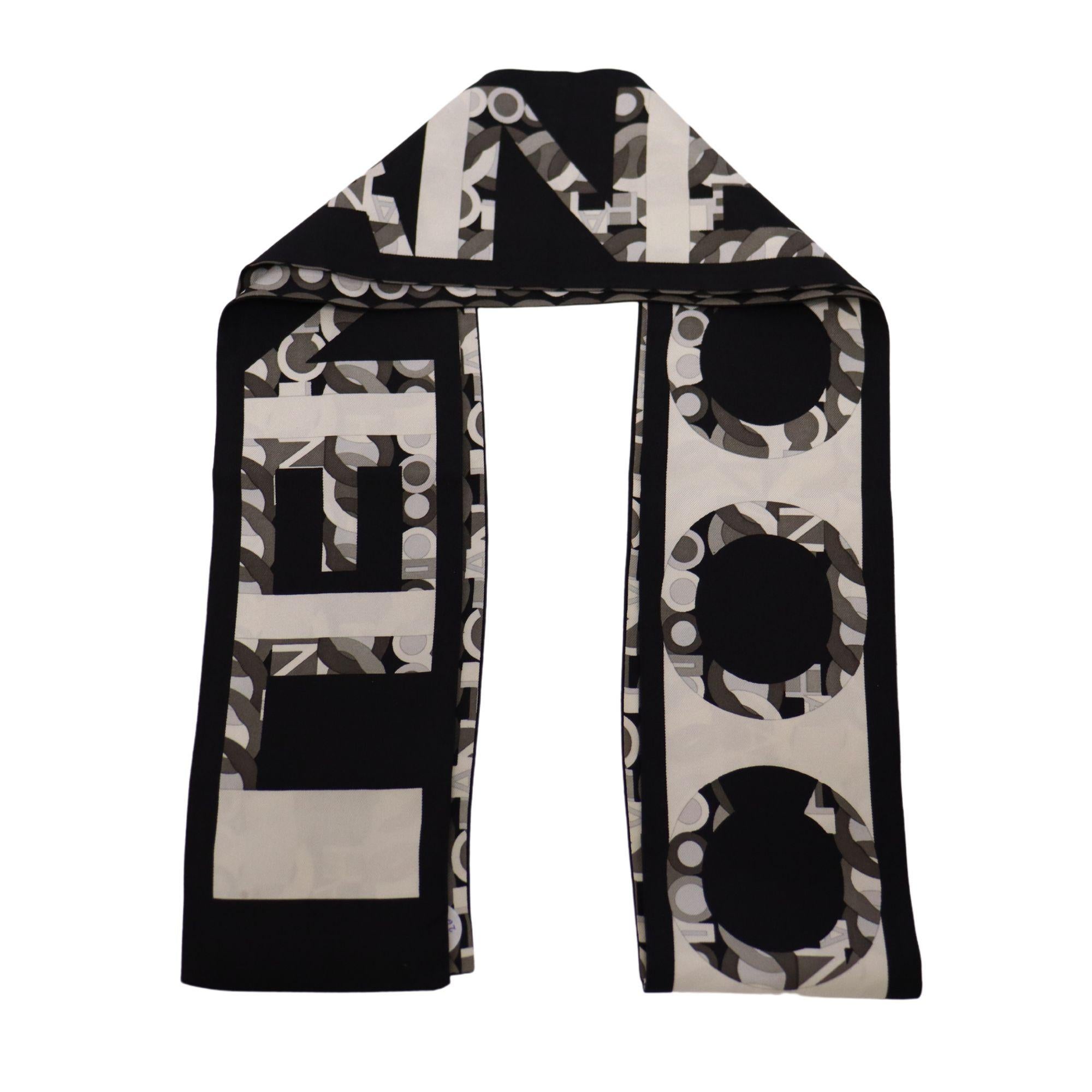 Black and grayscale chain and monogram print Chanel silk scarf. Chanel monogram and 'Chanel' letter grayscale print on the other side. 

Measurements:
9.5cmx155cm
