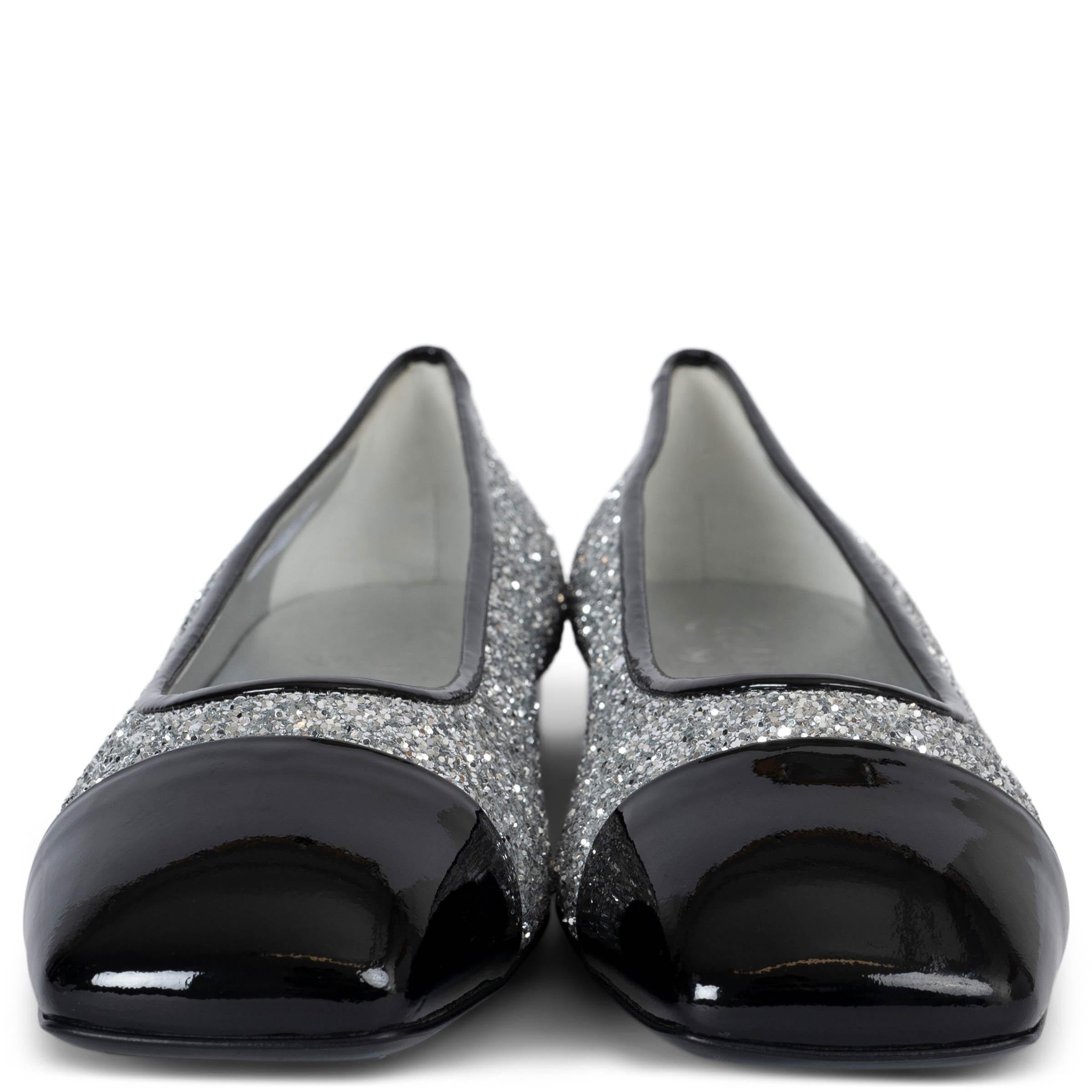 Questo paio di Chanel Glitter Fabric Patent Calfskin Mocassino in nero e argento è autentico al 100%. Questi splendidi mocassini sono realizzati in pelle di vitello verniciata lucida di colore nero, completata da un tessuto glitterato color argento