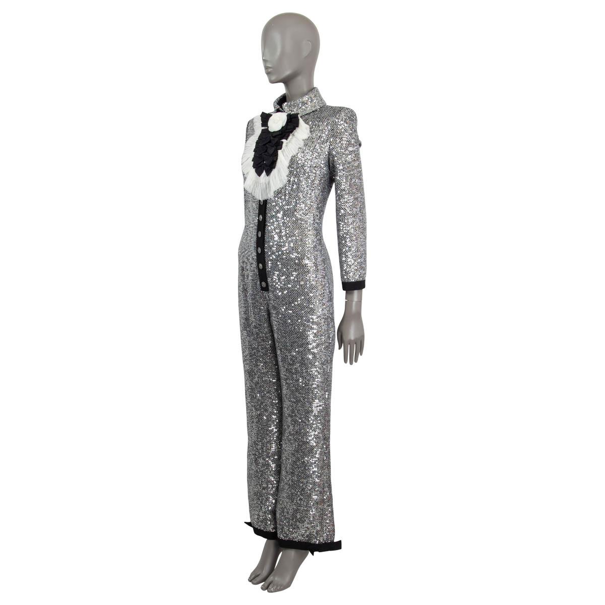 100% authentic Chanel long sleeve sequin jumpsuit in silver and black polyester (57%), cotton (22%), wool (17%) and metal polyester (4%). Features two side slit pockets, a grosgrain trim and bows on the pant cuffs. Comes with a detachable black and