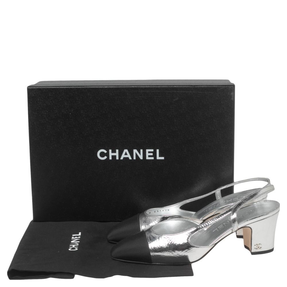With these sandals from the House of Chanel, your style will look stylishly glamorous and appealing! They are designed using silver-black leather and fabric on the exterior and display cap toes, block heels, and a slingback. Their heels are