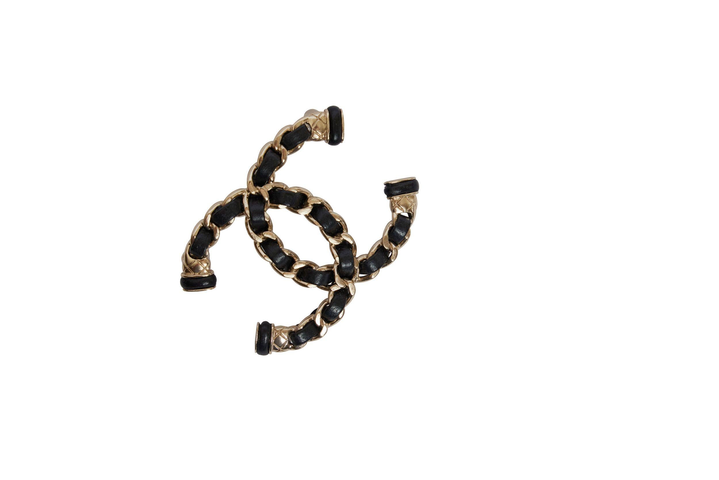 This CC logo brooch is made out of the typical Chanel handbag chain. It is silver metal with black lambskin leather. It is perfect for the evening but also cute with a jeans and blazer for everyday.