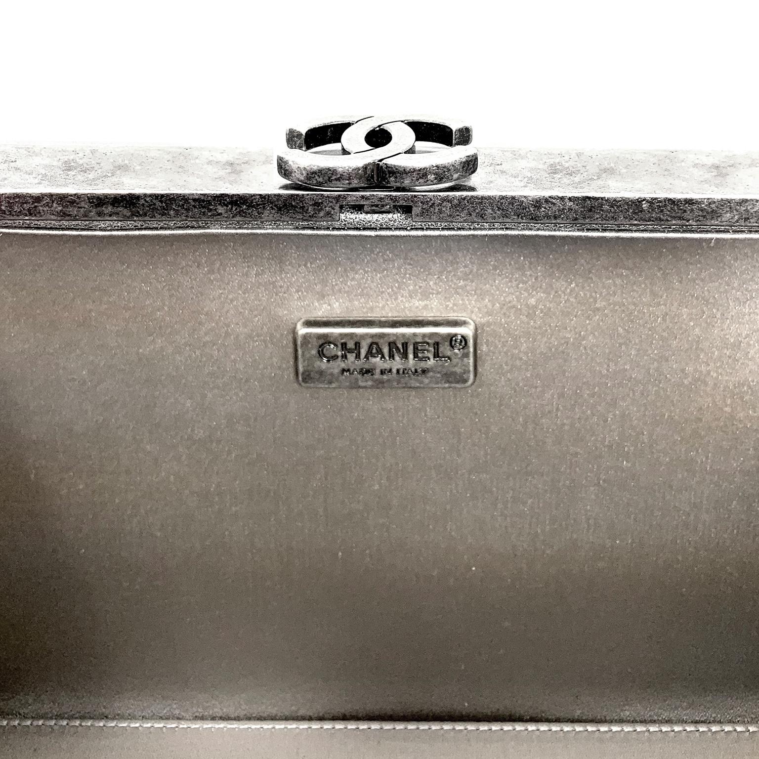 Cet authentique sac Chanel Silver Box est en excellent état.  Cuir argenté subtilement texturé avec des accents de quincaillerie en ruthénium.  Ouverture à charnière avec fermoir CC à verrouillage.  La longue lanière en cuir et chaîne entrelacée