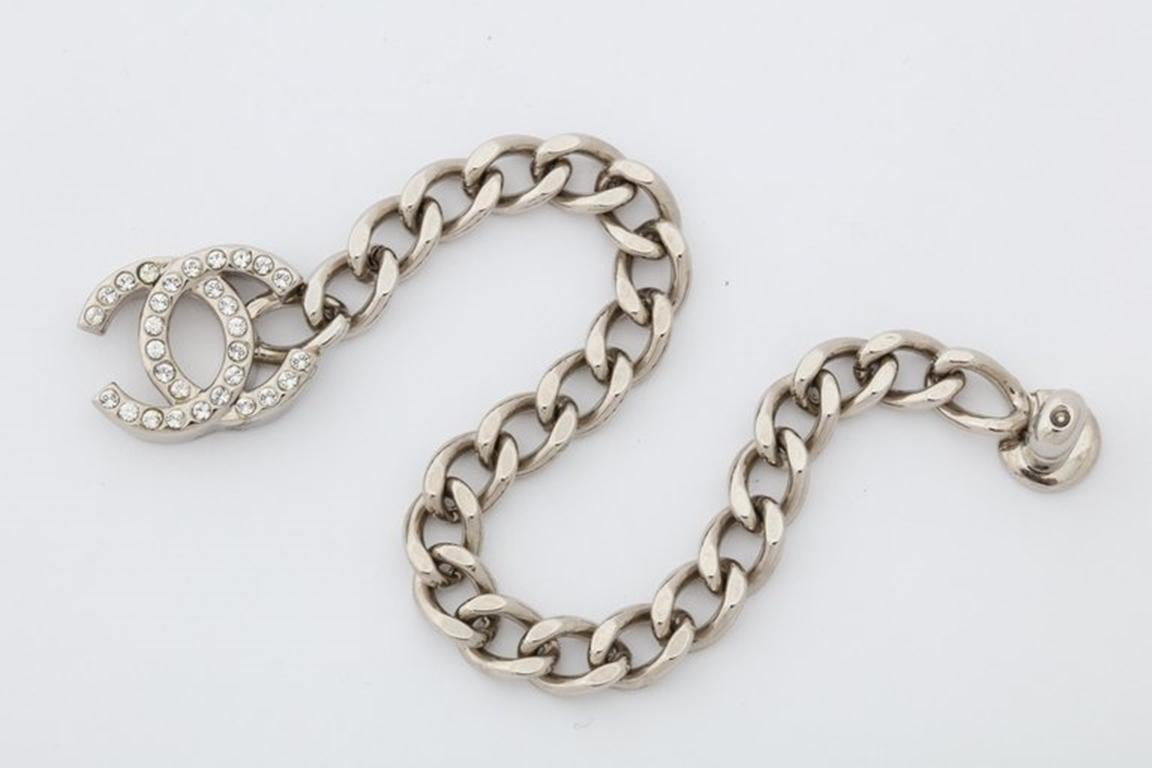 Chanel silver chain bracelet with iconic CC logo closure.

The logo has rhinestones.

The closure is 0.8 by 0.6 inches.

Signed Chanel.