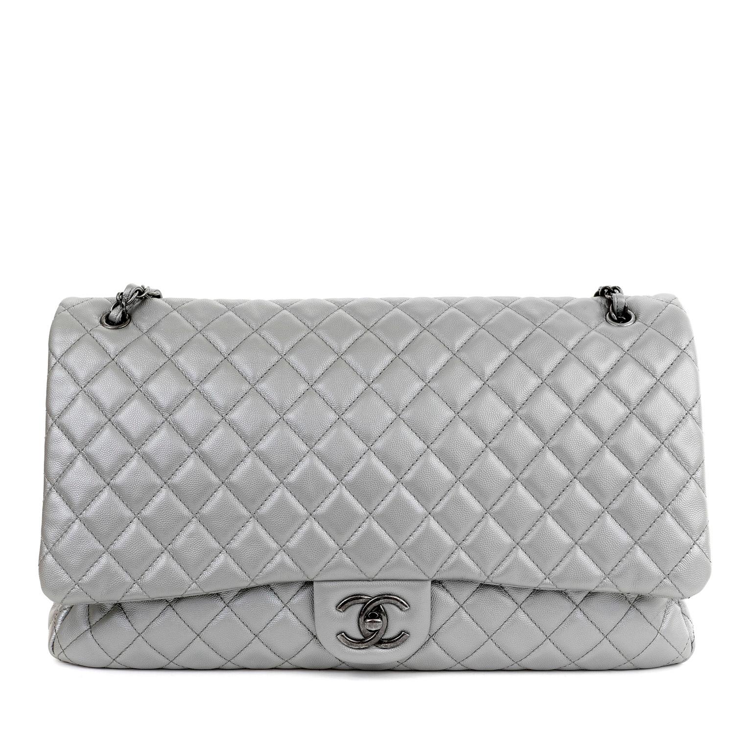 This authentic Chanel Silver Caviar Classic Travel XXL Flap Bag is in pristine condition.  Most certainly the chicest way to travel, this extra-large Classic Flap will get you there in style.

Silver caviar leather is quilted in signature Chanel
