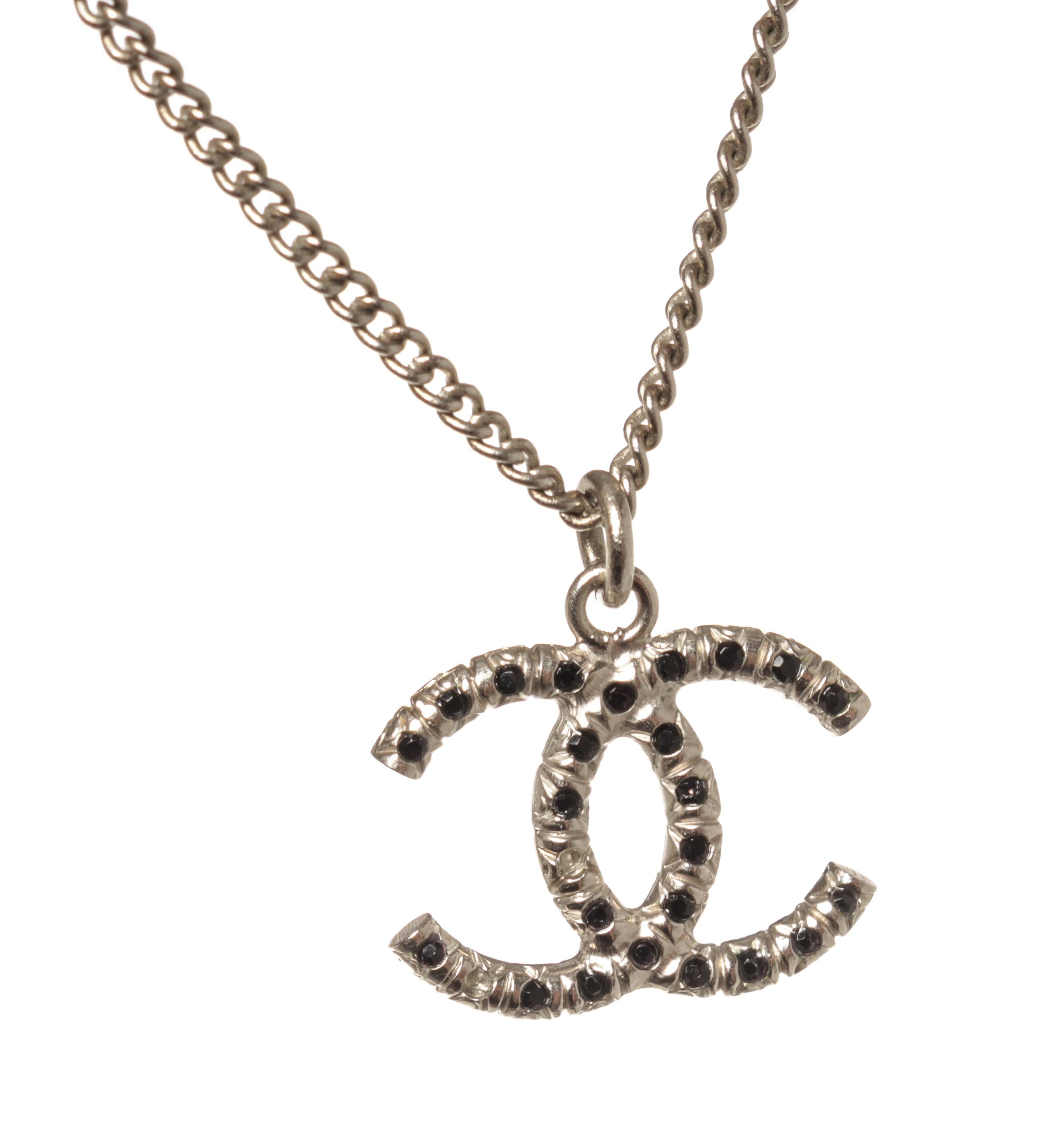 Chanel Silver CC Logo Rhinestone Necklace with silver tone metal hardware and link, black rhinestones, and lobster claw clasp.

770050MSC