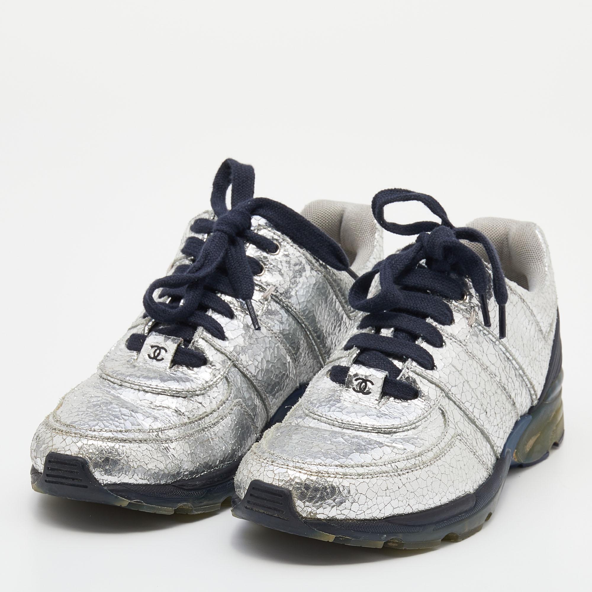 These sneakers from the House of Chanel are here to grant your feet the ultimate comfortable experience. They are crafted from silver crinkled leather into a sturdy low-top profile. They have lace-up fastenings on their vamps. Add these trendy