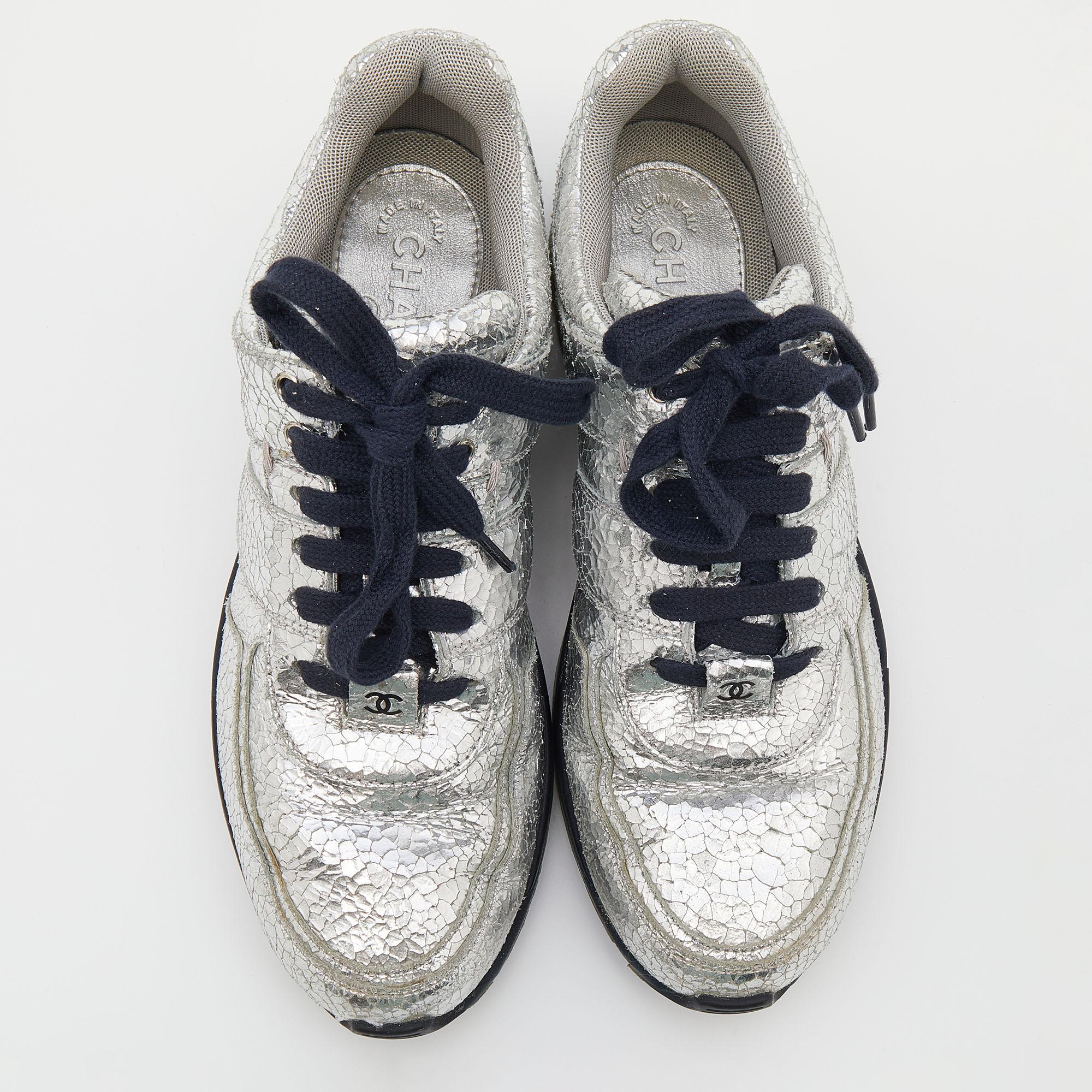 These sneakers from the House of Chanel are here to grant your feet the ultimate comfortable experience. They are crafted from silver crinkled leather into a sturdy low-top profile. They have lace-up fastenings on their vamps. Add these trendy