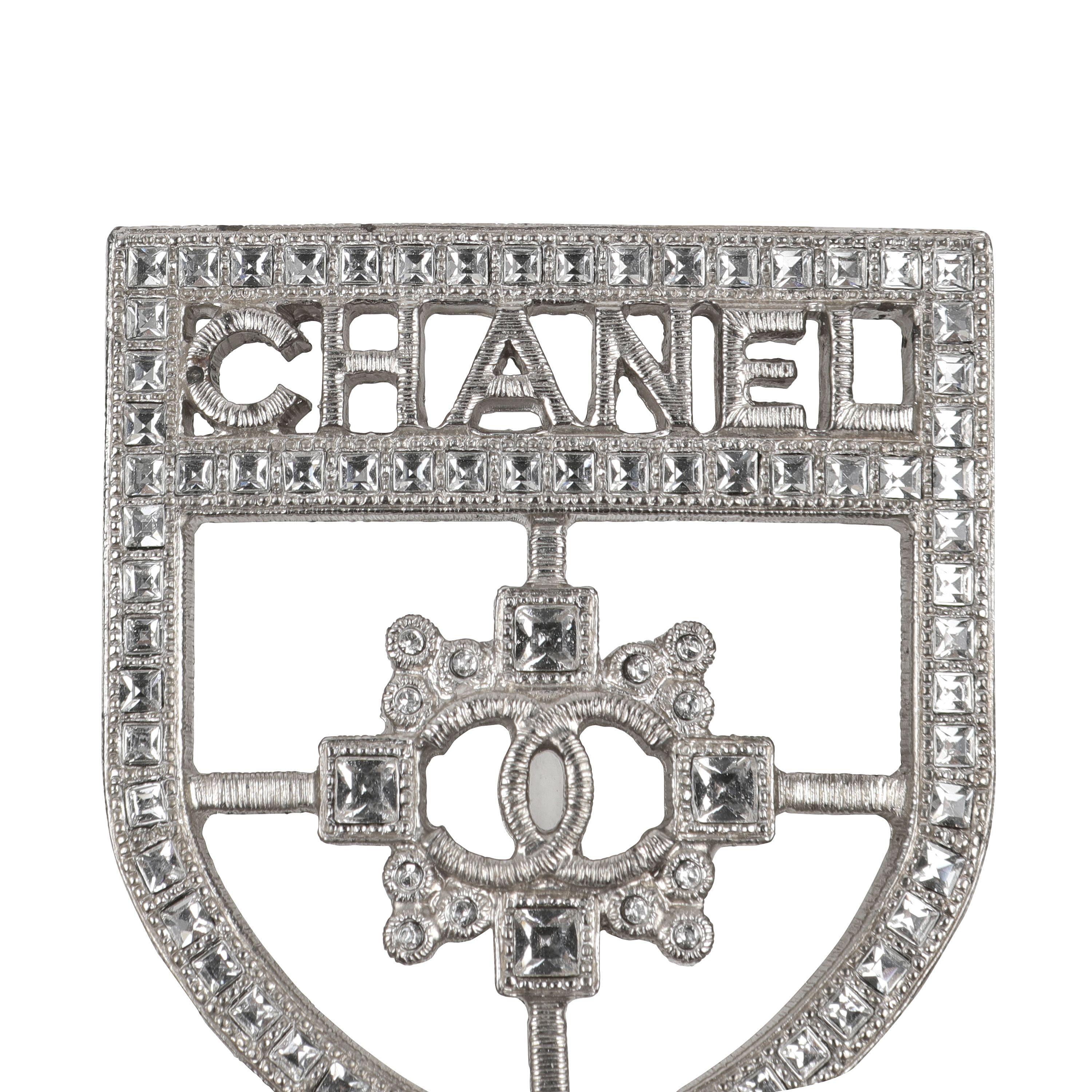 This authentic. Chanel Silver Crystal Crest Brooch is pristine.  Silver tone metal, clear crystal design. CC crest and CHANEL lettering.    Pouch or box included. 

PBF 13954
