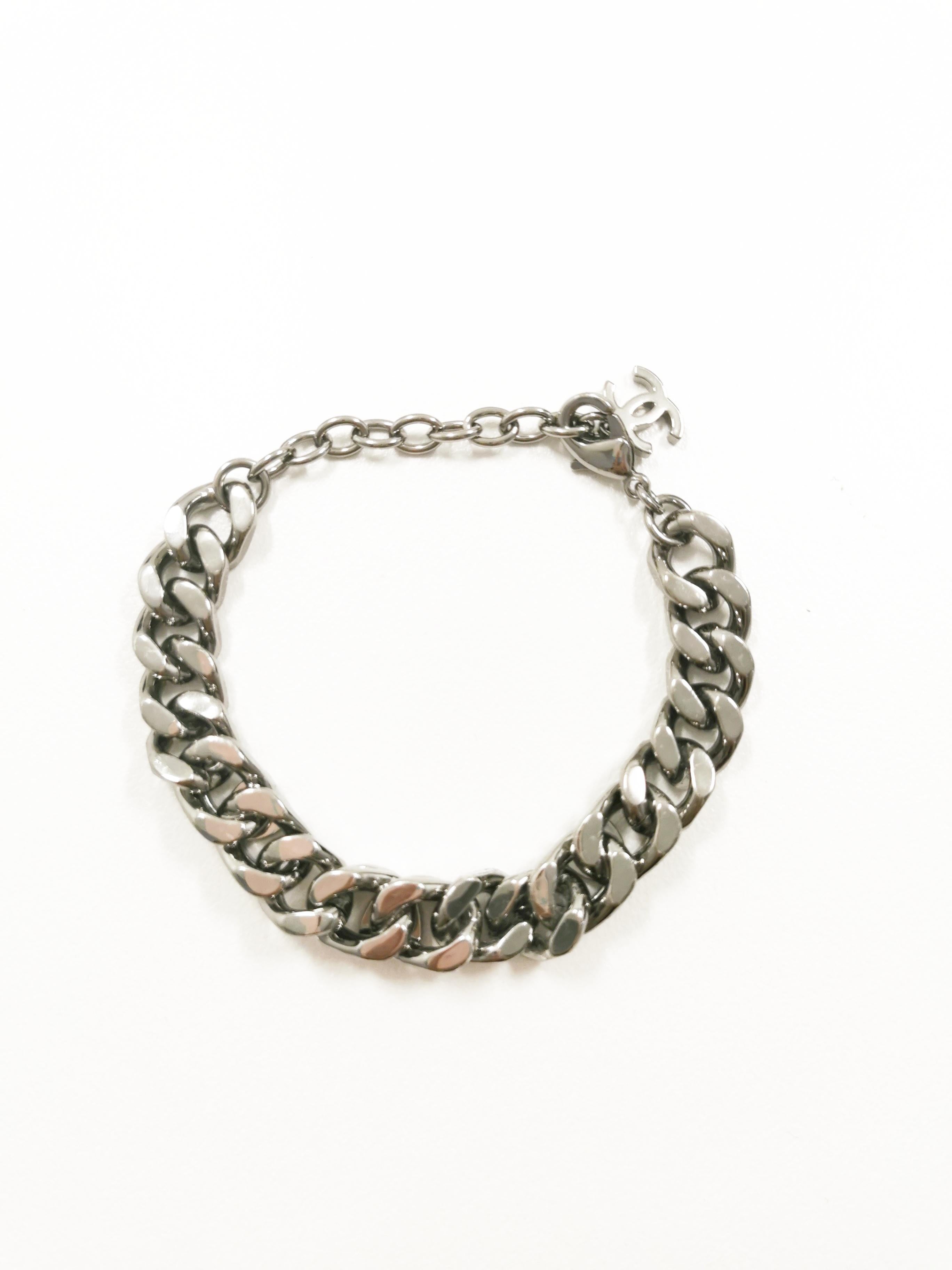 Step into the realm of edgy elegance with the Chanel Silver Gunmetal Cropped CC Logo Chain Bracelet. This statement piece seamlessly marries the iconic CC logo with a bold gunmetal chain, creating a distinctive accessory that exudes a fusion of