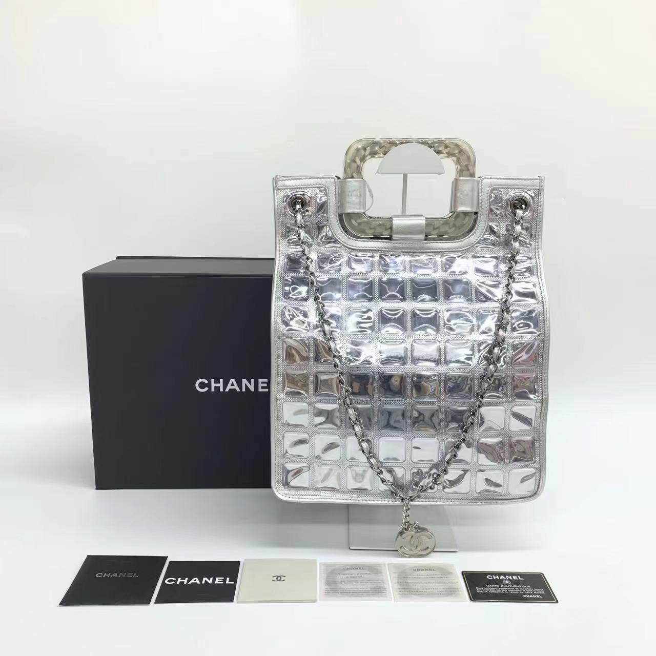 Chanel Silver Ice Cube Tote Leather and Vinyl with Chains
These are professional photos of the actual bag.
  This collectable charming collectible and highly sought after Chanel Silver Ice Cube Tote 2006-2008 is a stylish mix of classy and casual.