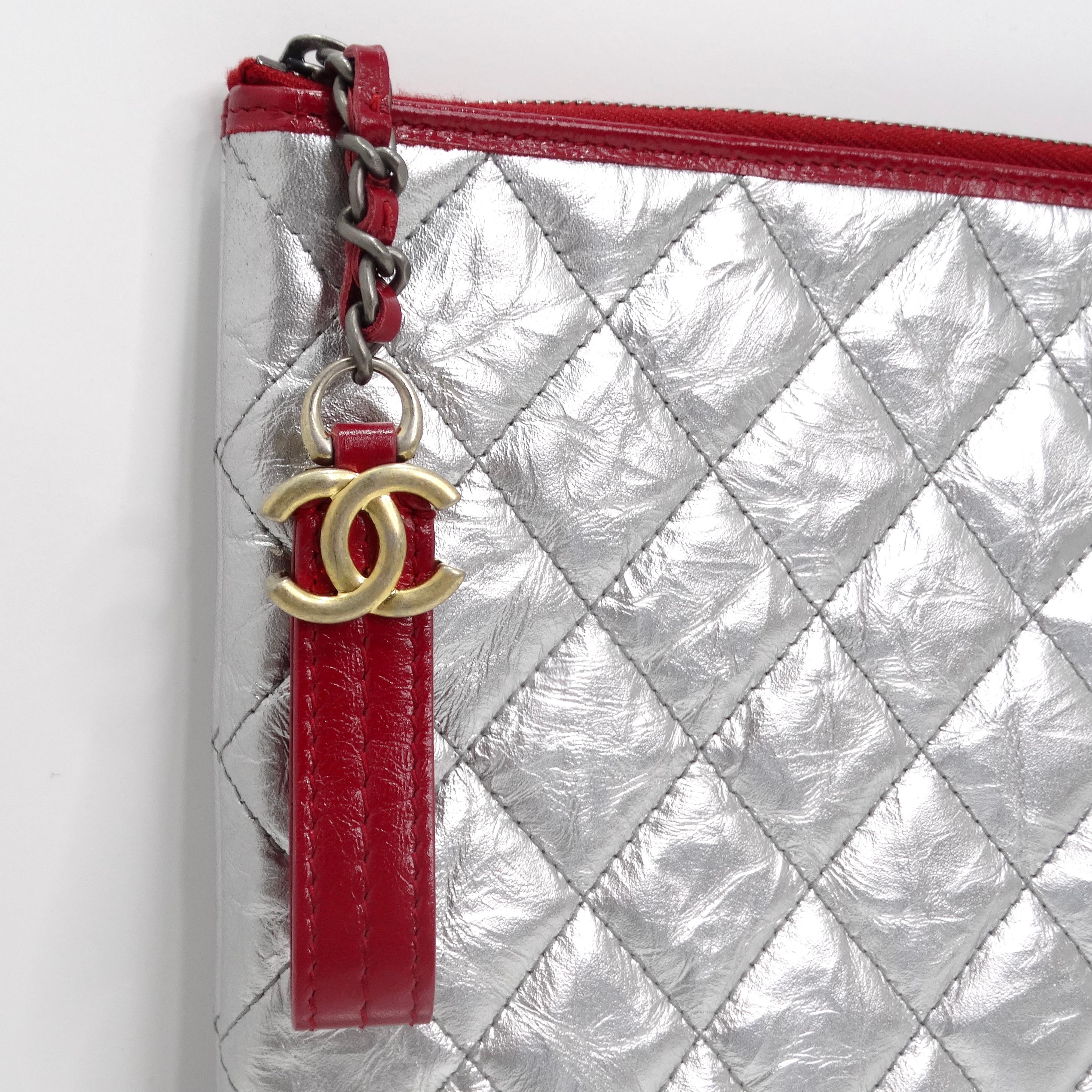 Introducing the Chanel Silver Leather Gabrielle Clutch – a timeless and chic accessory that adds a touch of modern elegance to any ensemble. Crafted from luxurious metallic silver leather, this large rectangular clutch exudes sophistication and