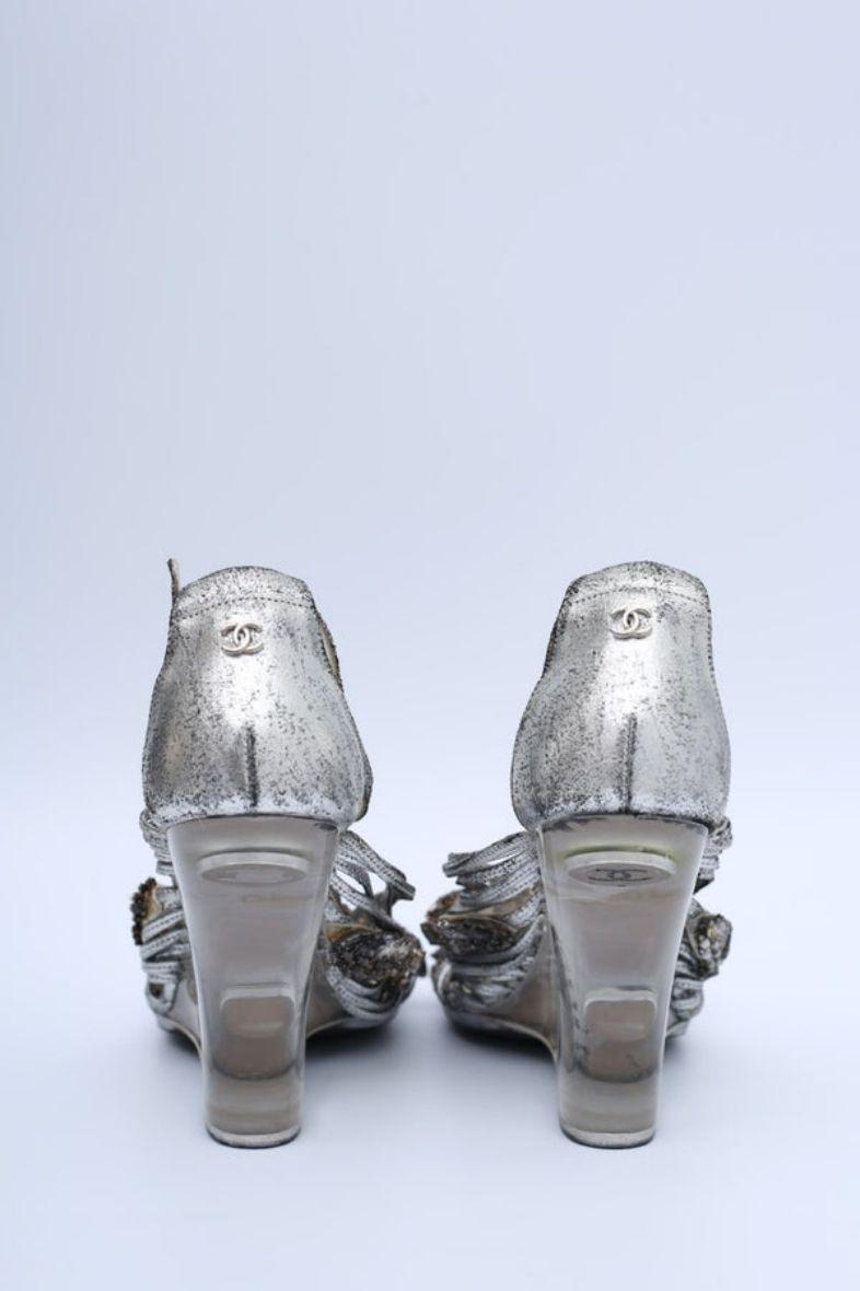 Chanel (Made in Italy) Wedge sandals with a transparent Plexiglas heel and silver leather straps. Size 40.

Additional information: 
Dimensions: Heel: 10.5 cm (4.13 in)
Condition: Good general condition. Some traces of glue and some wear on the