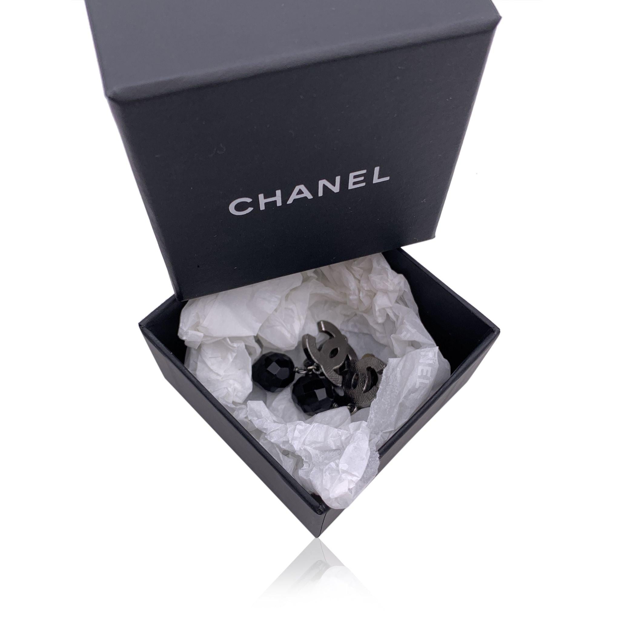 Gorgeous CHANEL silver metal CC logo earrings with dangling faceted black beads. Clip on design. Signed 'Chanel - 09 CC P - Made in France' oval hallmark on the reverse of the earring. Height: 30 mm Condition A - EXCELLENT Gently used. minimal green