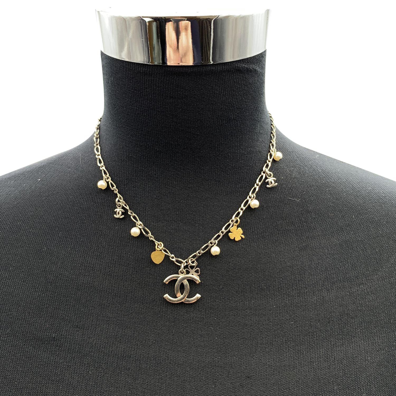 Hübsche Chanel-Halskette mit kleinen Charms. Es zeigt kleine goldene Kleeblätter, kleine Perlen und CC-Logos. Hummerverschluss. Gesamtlänge der Kette: 16,5 Zoll - 41,9 cm. Ovale Marke 'CHANEL 06 CC V - Made in France' am Ende der Kette. Zustand A -