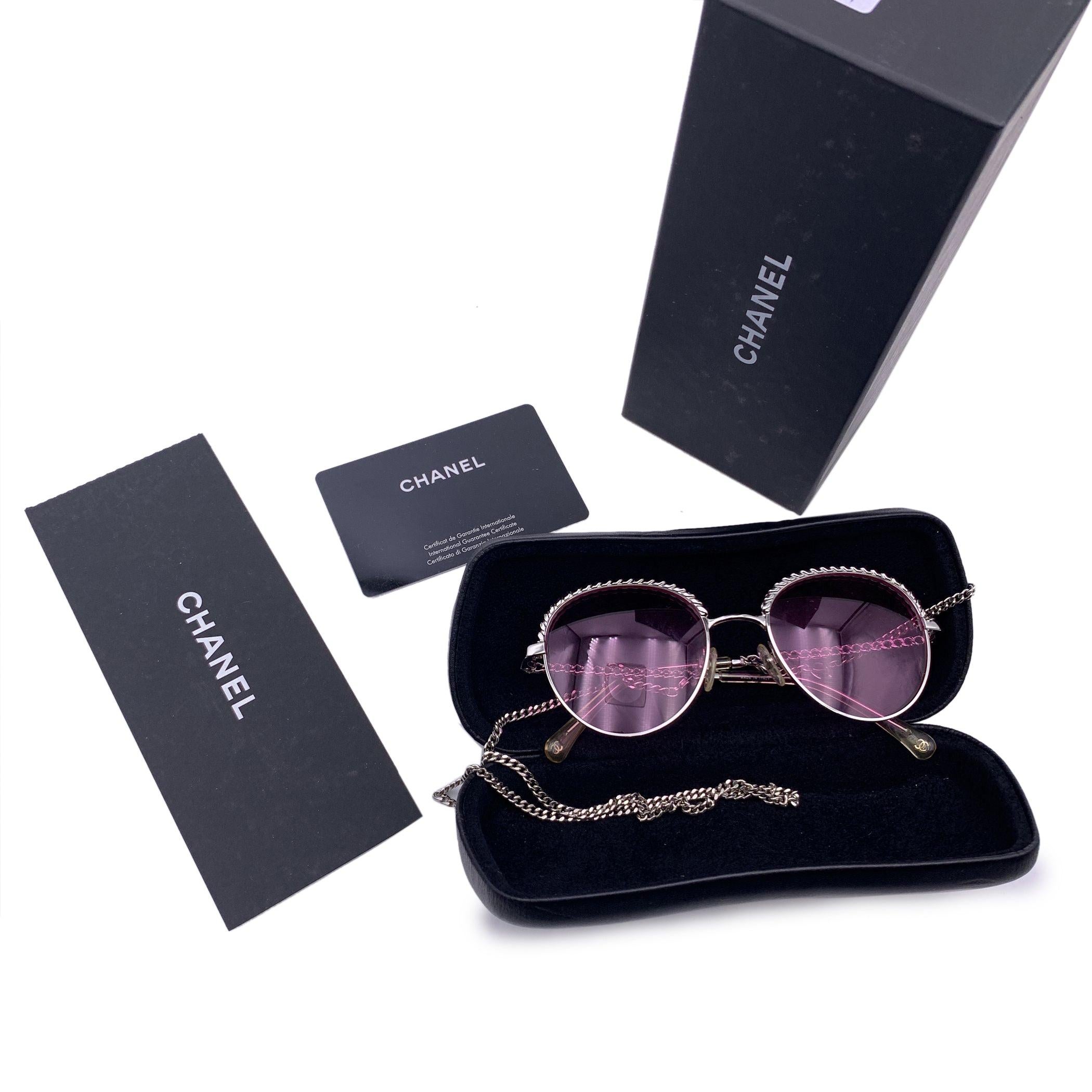 Chanel Pantos sunglasses mod. 2184 - c.124. They feature silver metal frame with chain detailing on the ear stems and on the upper part of the frame. Removable glasses chain with CC logo included. Pink lenses. Mod & refs.: mod. 2184 - c.124 - 50/19