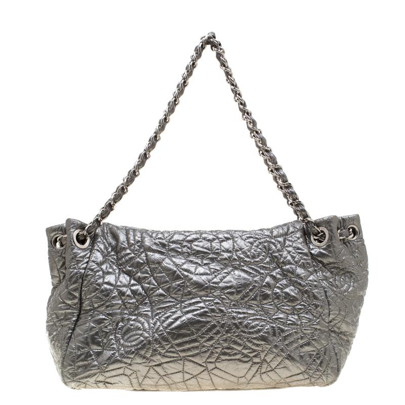 Eye-catching in appeal, this Edge flap bag is designed in a silver patent vinyl with a graphic pattern on it. Ideal for evenings and parties, this bag comes with signature woven chain handles and a flap with the CC logo. The bag is ready with a