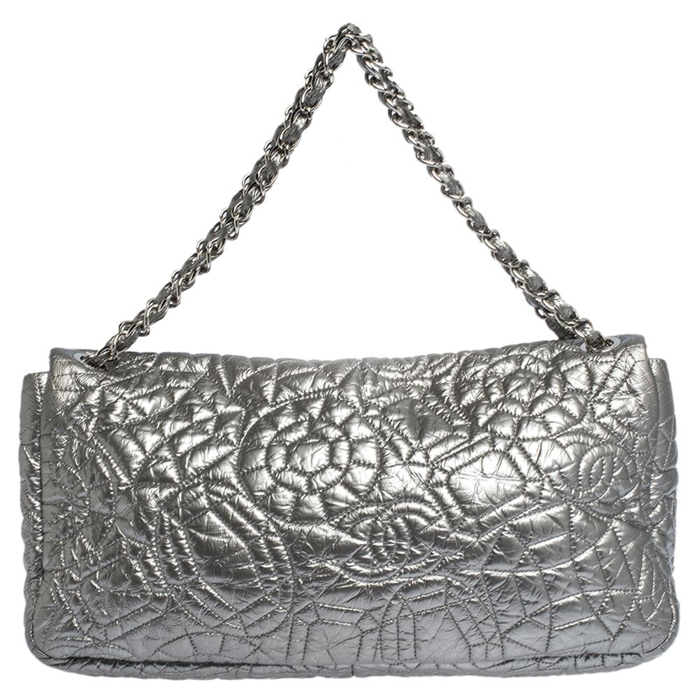 Bold and edgy, this Classic flap style bag is designed in a silver patent vinyl with a graphic pattern on it. Ideal for evenings, this bag comes topped with two sleek chain straps and is secured with a 'CC' lock closure. It comes with a satin