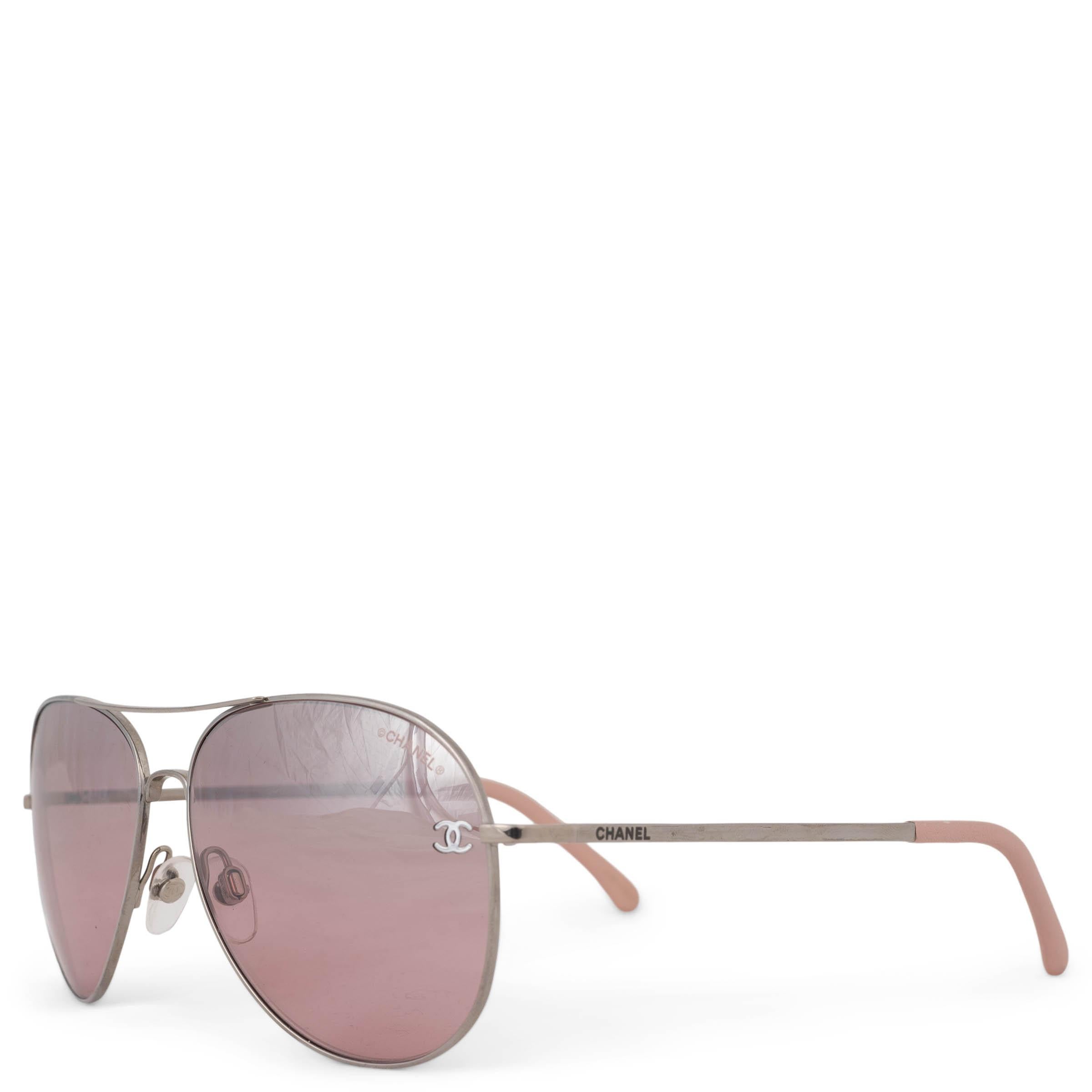 This 100% authentic Chanel Pilot sunglasses with silver titanium wire frame embody sleek sophistication. Featuring grey aviator lenses with a striking pink mirrored finish on the outside, they offer a bold yet refined aesthetic. The design is