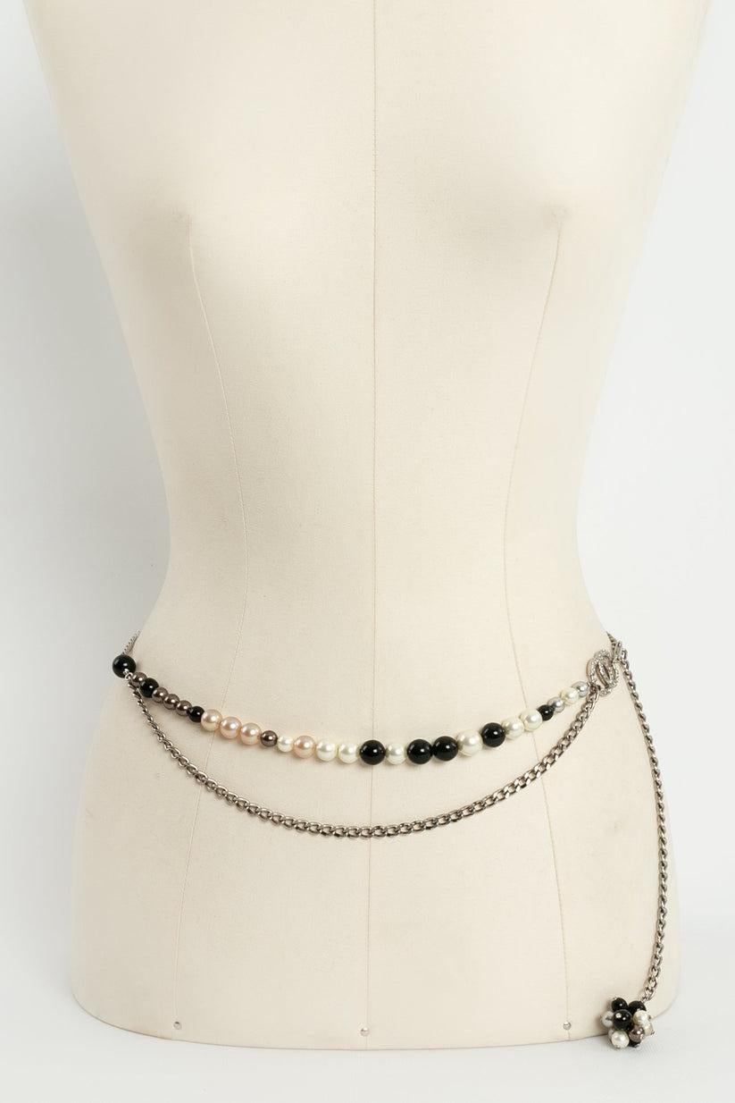 Chanel (Made in France) Belt in silver plate and pearly and black beads. 2004 Spring-Summer Collection.

Additional information: 
Dimensions: Length: 33 cm to 89 cm (13
