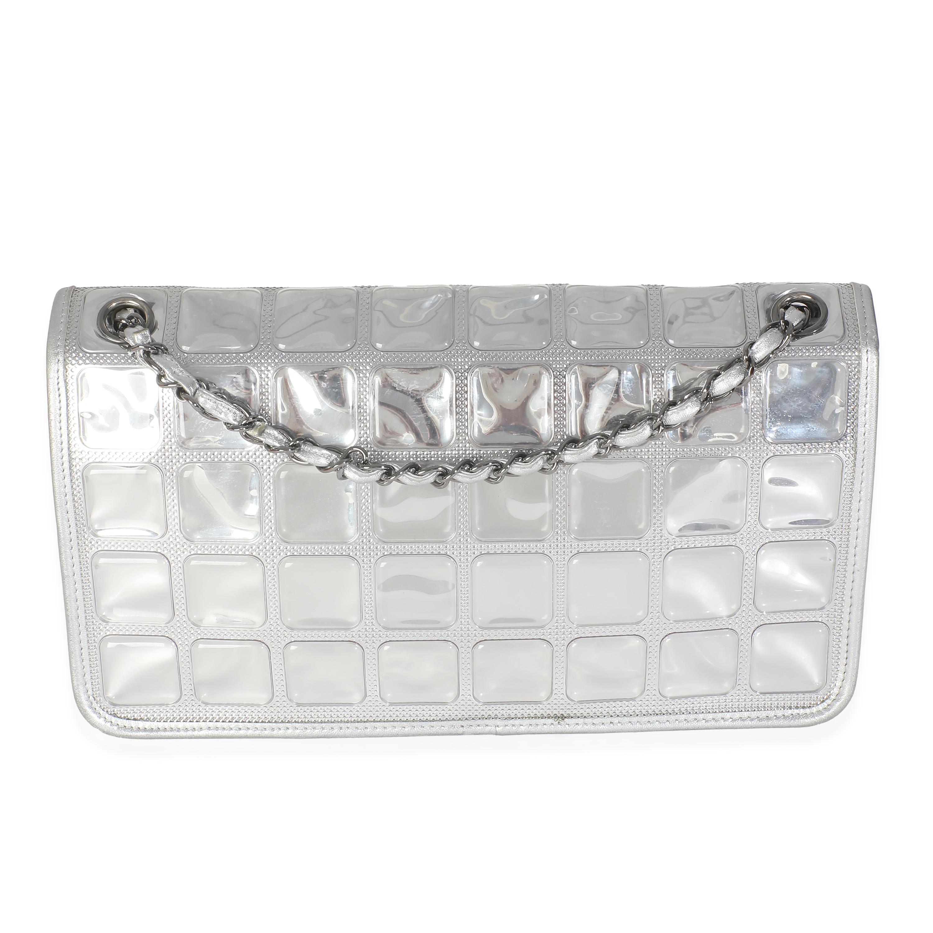 Listing Title: Chanel Silver PVC Calfskin Ice Cube Flap
SKU: 146282
Condition: Pre-owned 
Condition Description: A timeless classic that never goes out of style, the flap bag from Chanel dates back to 1955 and has seen a number of updates. The