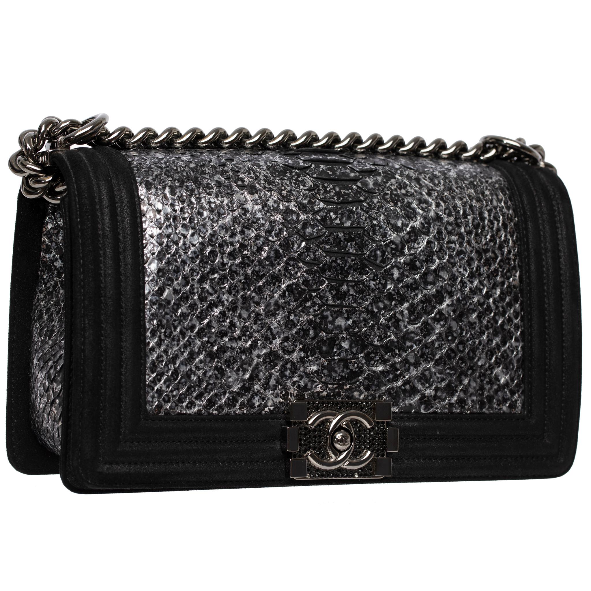 This Chanel Medium Le Boy bag exemplifies exceptional craftsmanship with its metallic python leather exterior and black goatskin leather trim. The Ruthenium hardware adds a lovely finishing touch to this classic collector's item, dating back to