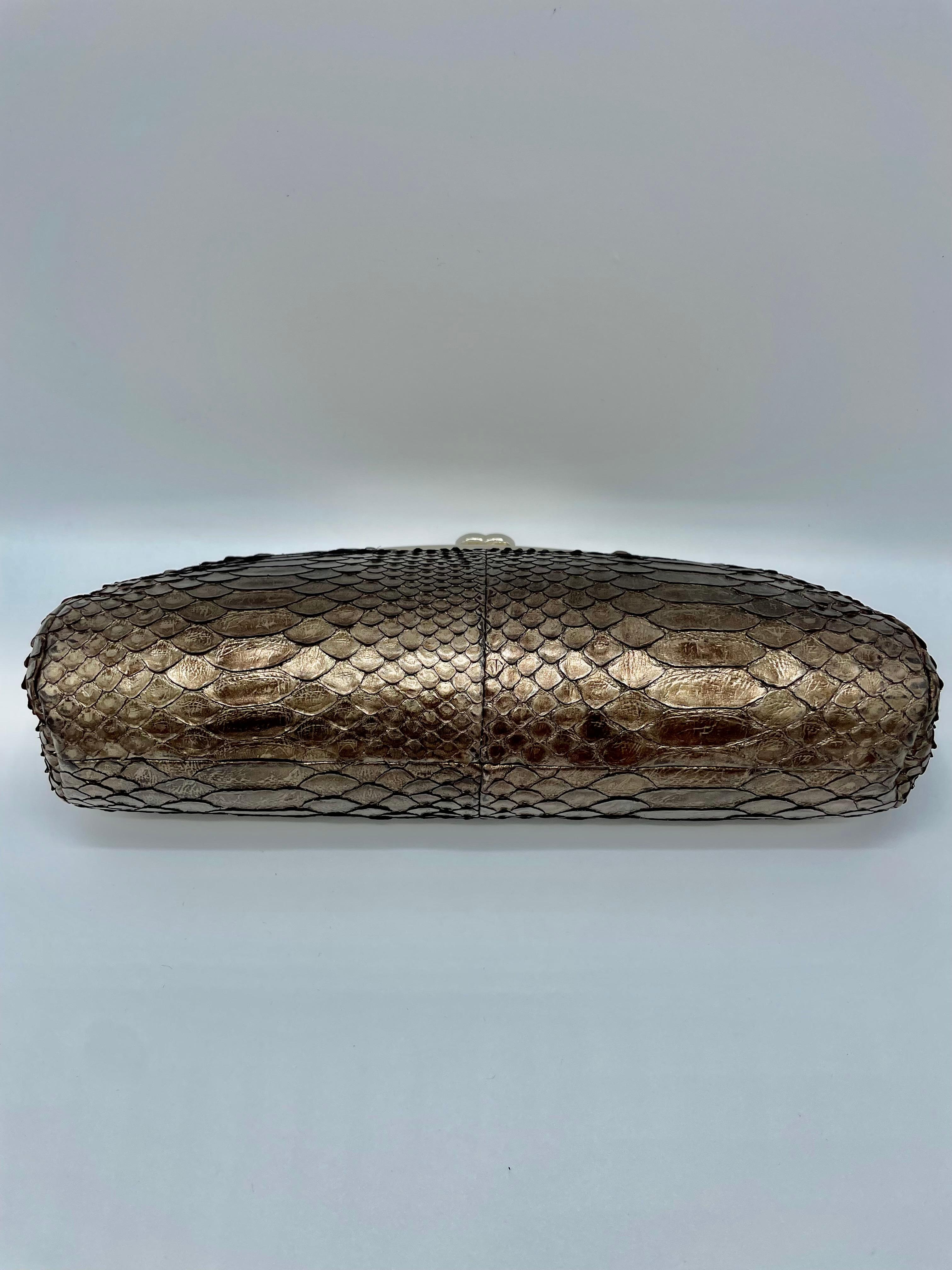 Python clutch by Chanel. The color silver is reflected by the sun and generates distinct hues. This gorgeous bag is a one-of-a-kind, very rare collectible. This clutch is easy to carry and complements any ensemble, making it ideal for several